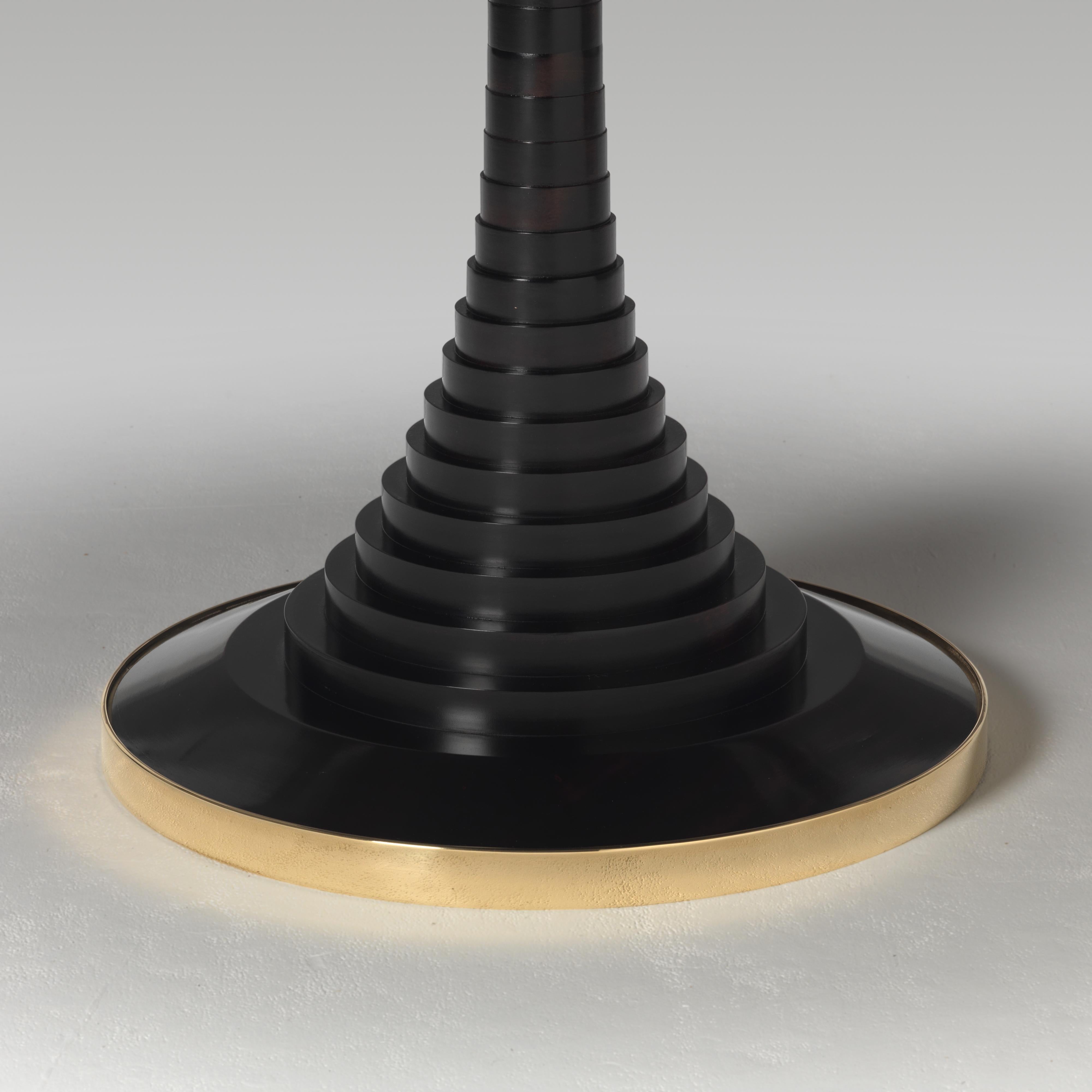 Une belle table circulaire marquetée s'inspirant de Ralph Turnbull. Le plateau circulaire est orné d'un motif géométrique incrusté de bois de spécimen rayonnant. Le plateau de forme classique est soutenu par une colonne ébonisée contrastante,