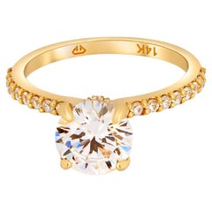 La bague de fiançailles de fiançailles en or 14 carats avec halo veiled et moissanite brillante ronde. 