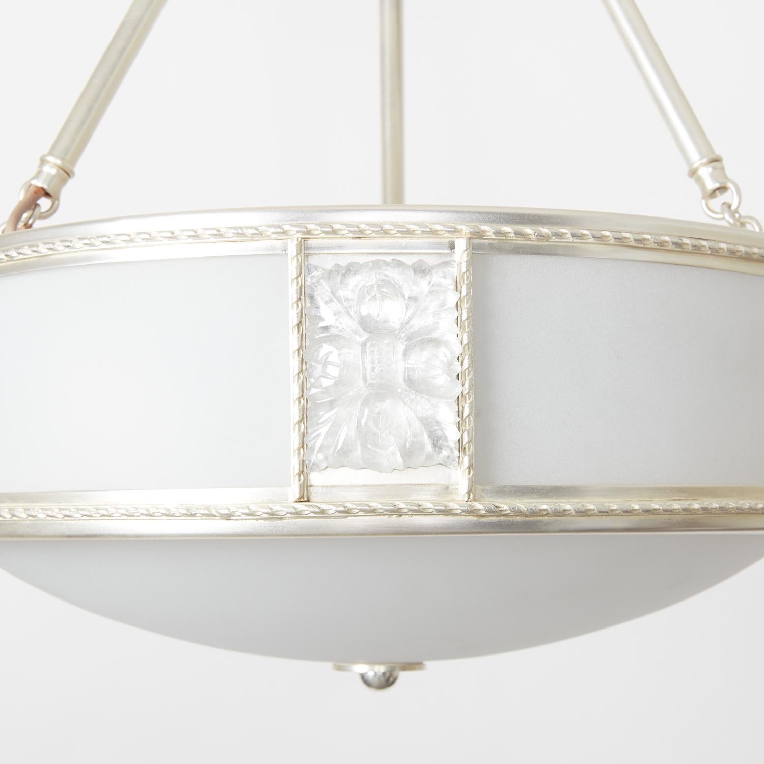A pendant light fixture by David Duncan, with curved frosted glass sides and underside, rock crystal rosettes, and a silver plate finish. This elegant fixture is suspended by three rods and features canopy adorned by cast brass sunburst.