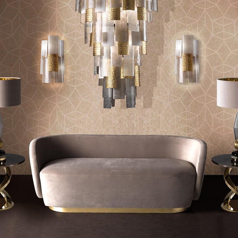 This sconce is part of the home couture collection, and serves as elegant source of light, while also being a splendid jewel for a wall. Its sculptural stricture combines curved glass elements that alternate smooth and grooved textures for a dynamic