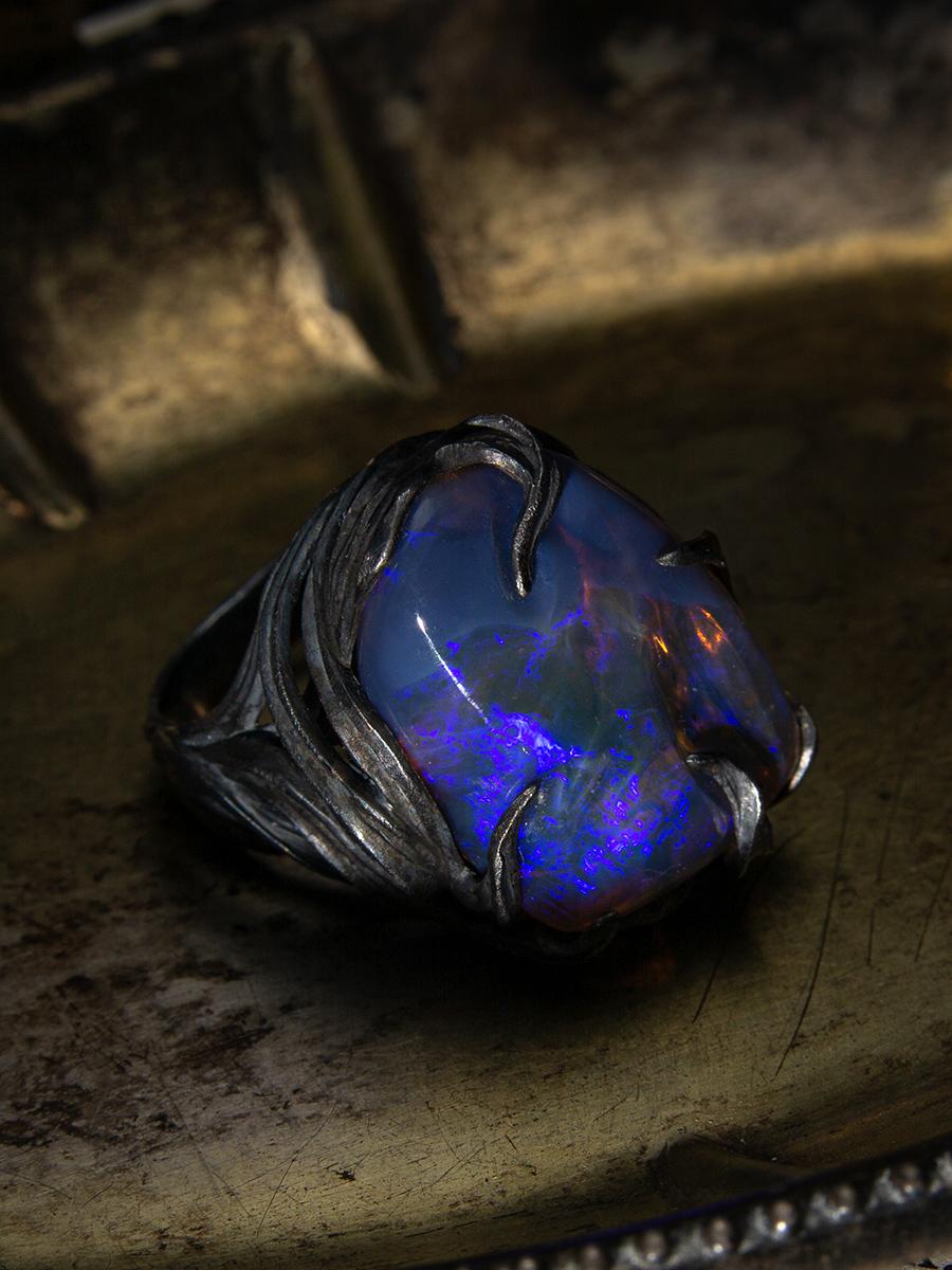 Inspired by the sun as it breaks through the dark night, this magnificent ring features fantastical blackened silver waves painstakingly created by hand. An Australian neon blue opal sits in the center, encased by highly detailed, dimensional