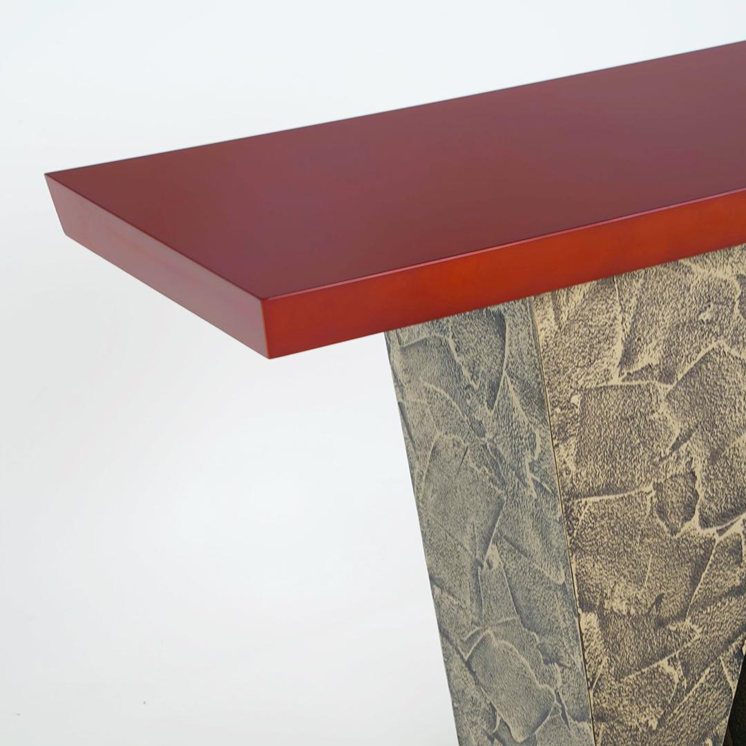 Der Wedge Konsolentisch ist ein modernes Meisterwerk, das kühnes Design mit hochwertiger Handwerkskunst verbindet. Dieses atemberaubende Stück zeichnet sich durch eine einzigartige Basis aus ineinandergreifenden Keilen aus, die eine auffallend