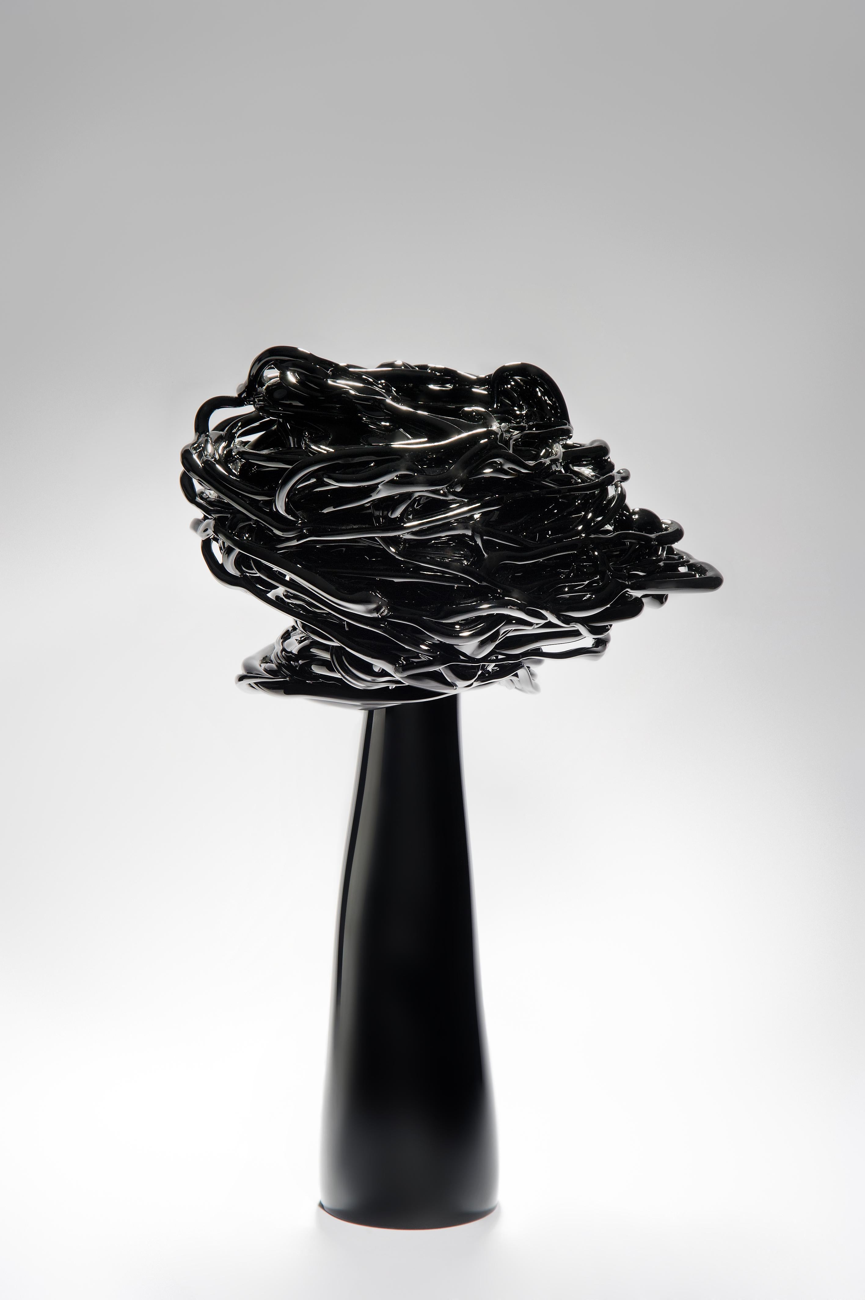 Le vent de la nuit est une sculpture unique d'arbre stylisé en verre noir réalisée par l'artiste lituanien Remigijus Kriukas. Le verre est soufflé et sculpté à chaud pour créer cette œuvre d'art substantielle, qui est à la fois frappante et