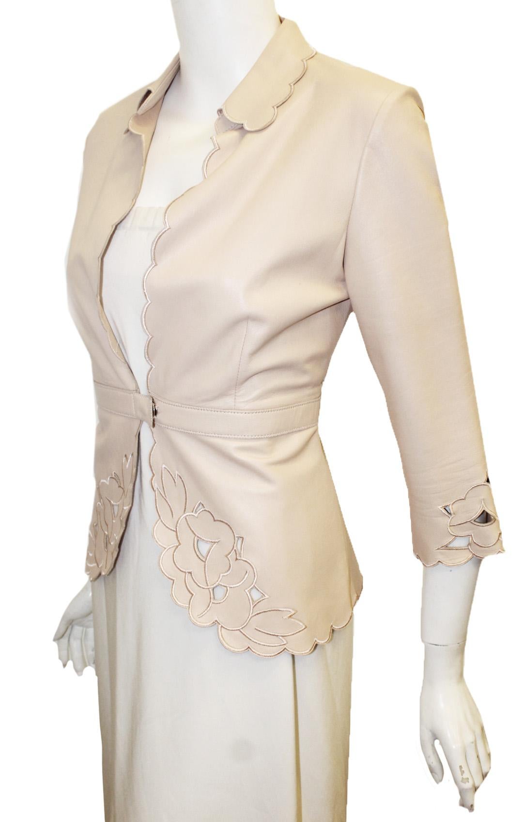 The Wrights beige leather jacket is laser cut with flowers on sleeve cuffs and at front cutaway.   The finishing touch is embroidering around cutouts.  This jacket has scalloped edges on the collar, front opening and around the hem.  A single snap