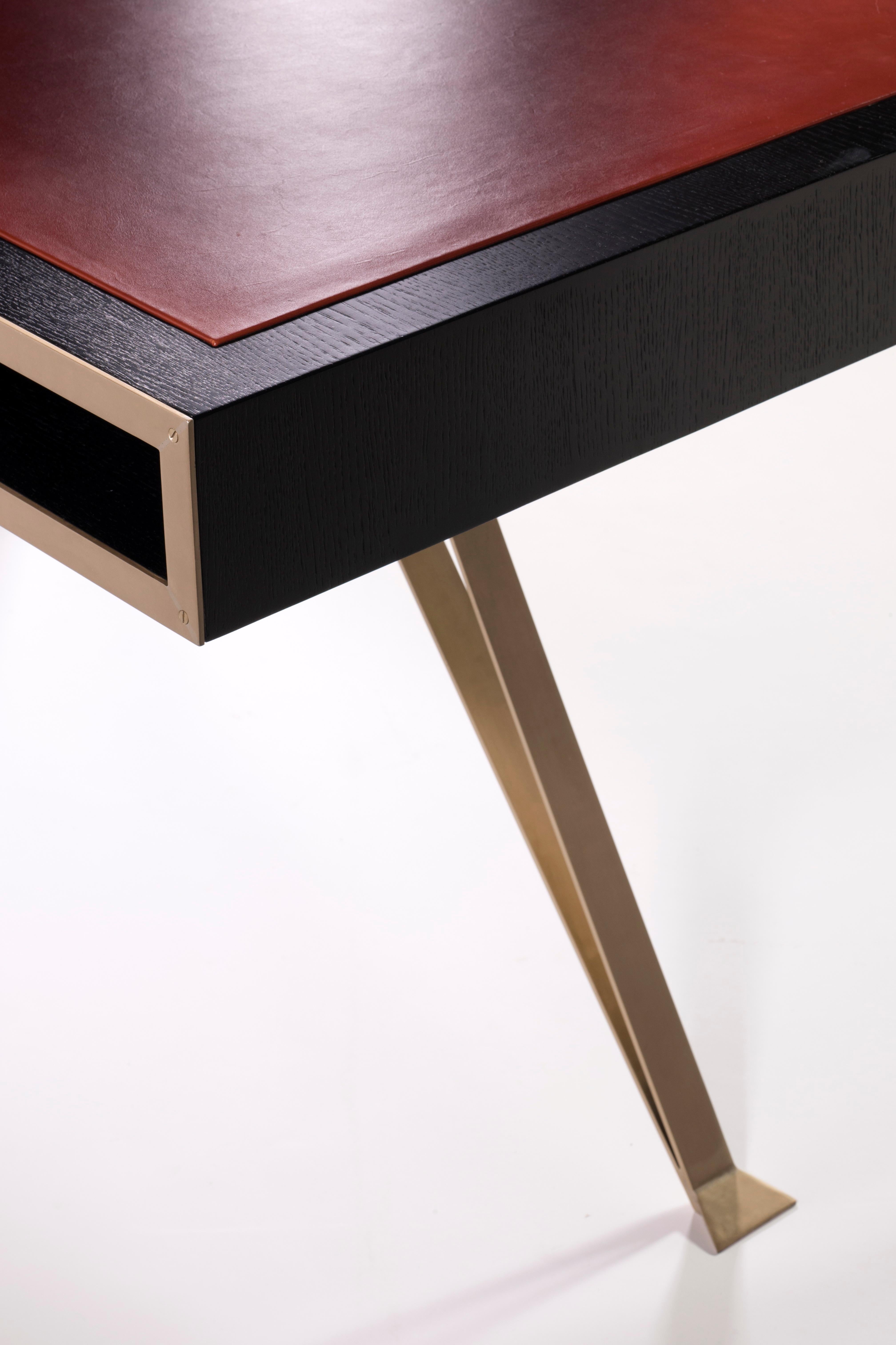 An oak, brass and leather writing desk
B.B. - Strong contrasting materials combine – I love how the boxy table and drawers seem to float and balance on different tripod legs. Note the wide open shelf-like storage space underneath the writing