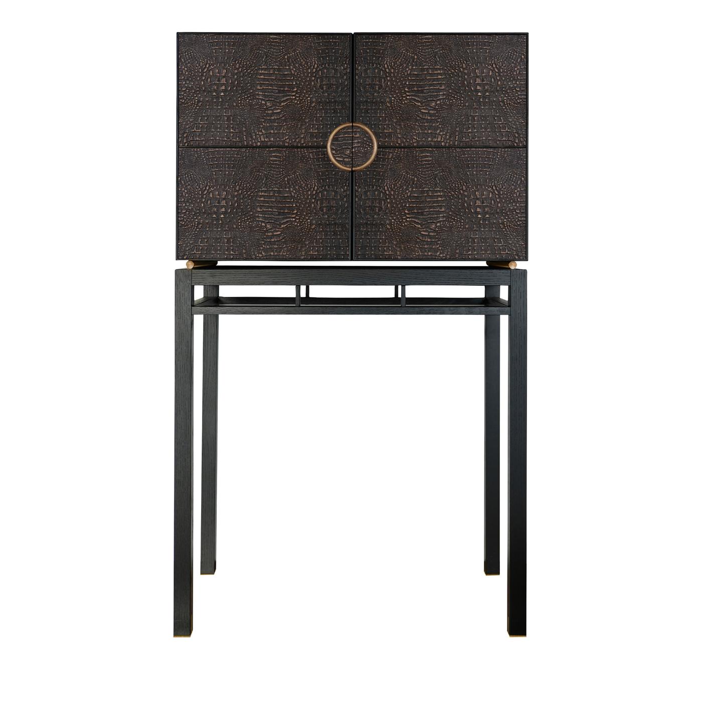 This bar cabinet perfectly embodies the harmony between refined sophistication and essential functionality. Crafted of stained oakwood, its two doors are upholstered with crocodile-stained cork and are equipped with a galvanized bronze handle