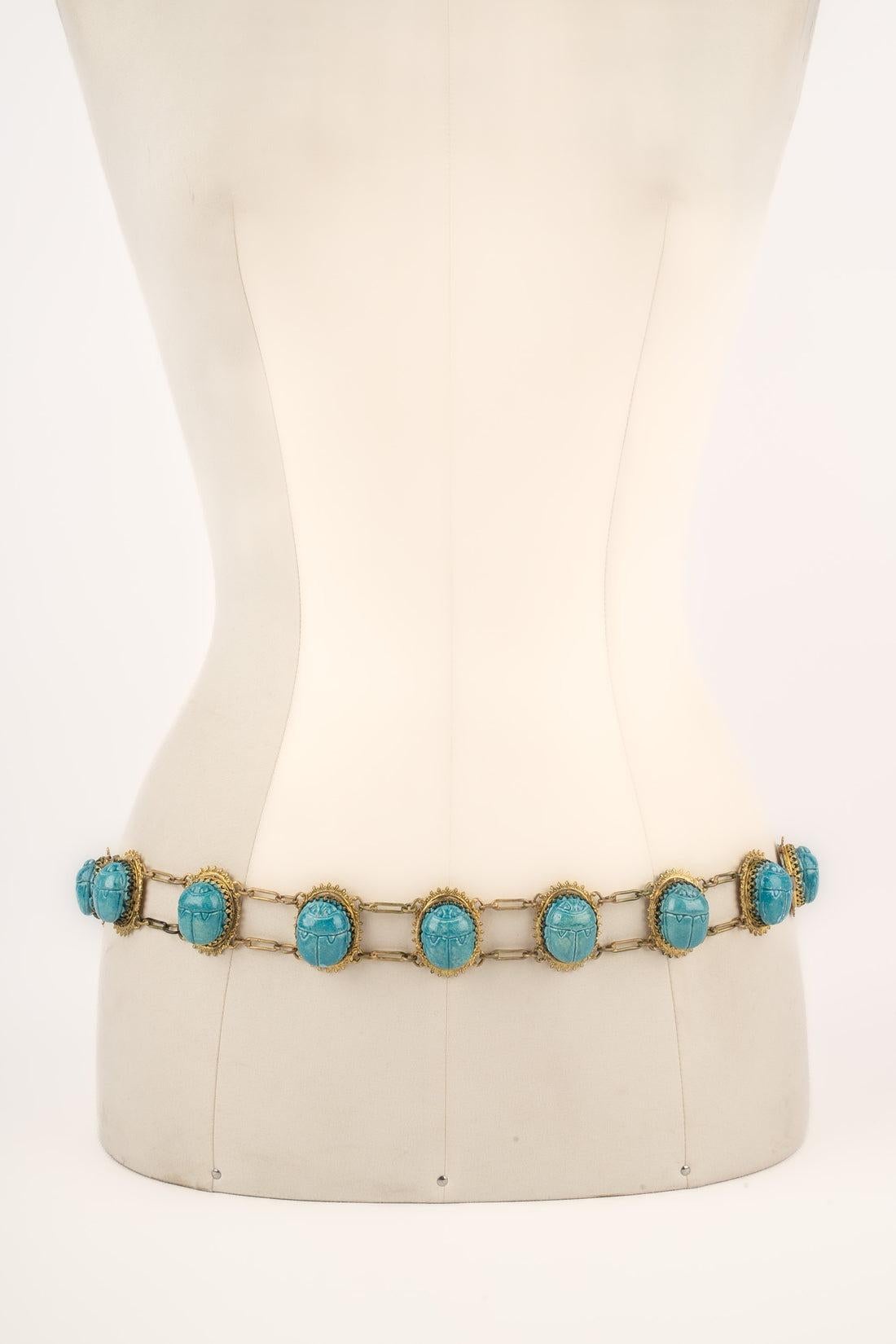 Theater - Golden metal belt decorated with blue beetles.

Additional information:
Condition: Good condition
Dimensions: Length: 85 cm

Seller Reference: TACC4