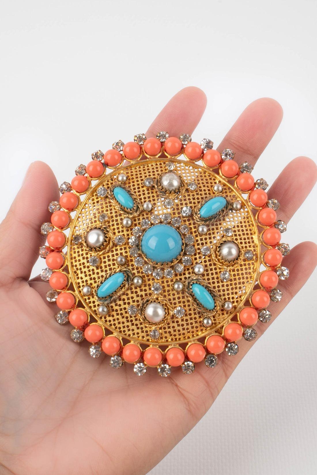 Theater - Golden metal openwork circular brooch with blue glass paste cabochons, resin pearls, and costume pearly cabochons.

Additional information:
Condition: Good condition
Dimensions: Diameter: 8.5 cm

Seller Reference: TBR3