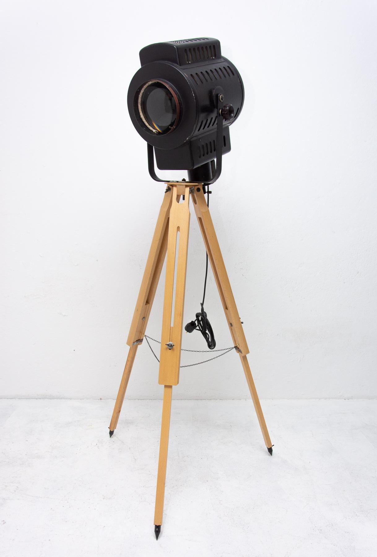Vintage Industrial spotlight on a wooden tripod. It was made in the former Czechoslovakia in the 1970s. It features an original large rounded shade. Provides a high level of lighting. An outstanding and attractive model. To be used for theatre