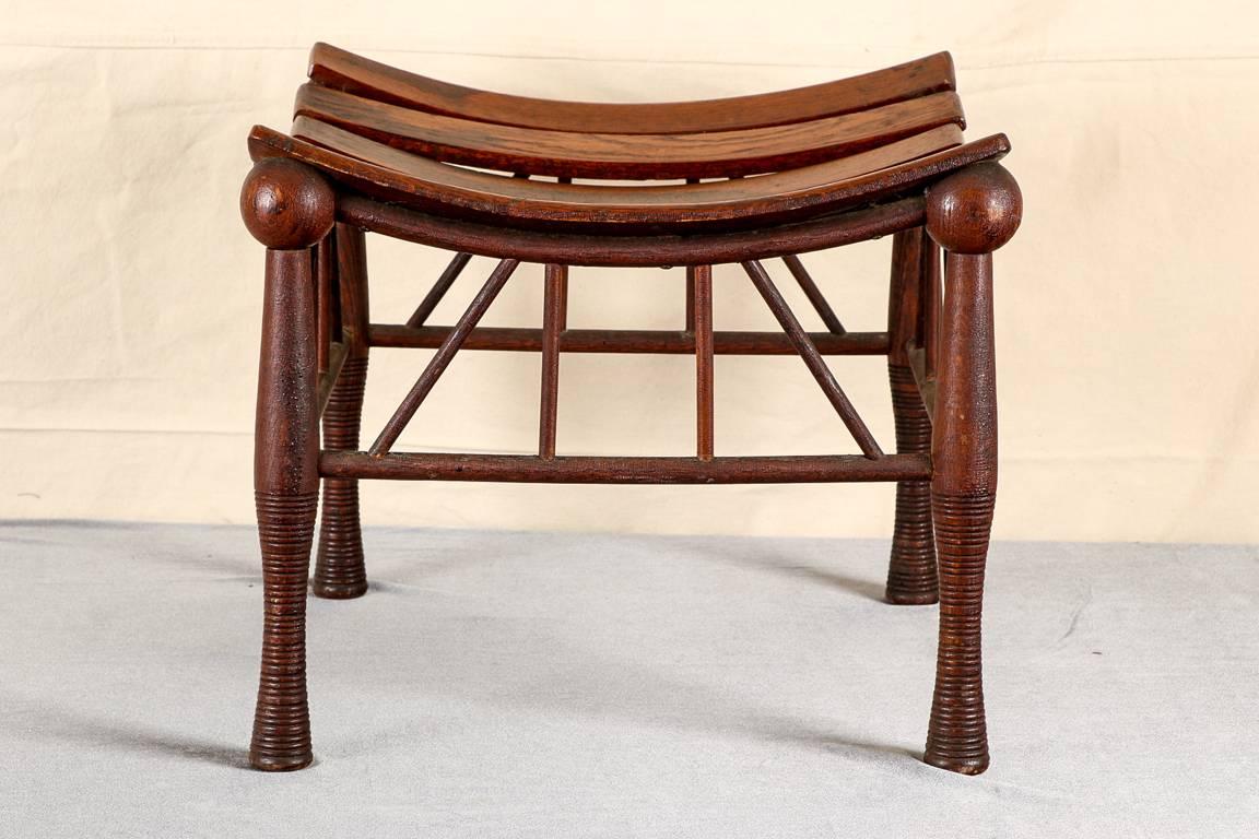 Thebes stick and ball stool, oak stool in the ancient Egyptian manner with a shaped slatted seat raised on ribbed stick and ball legs, four cylindrical stretchers on each side. 

Condition: Expected wear and signs of use including some light