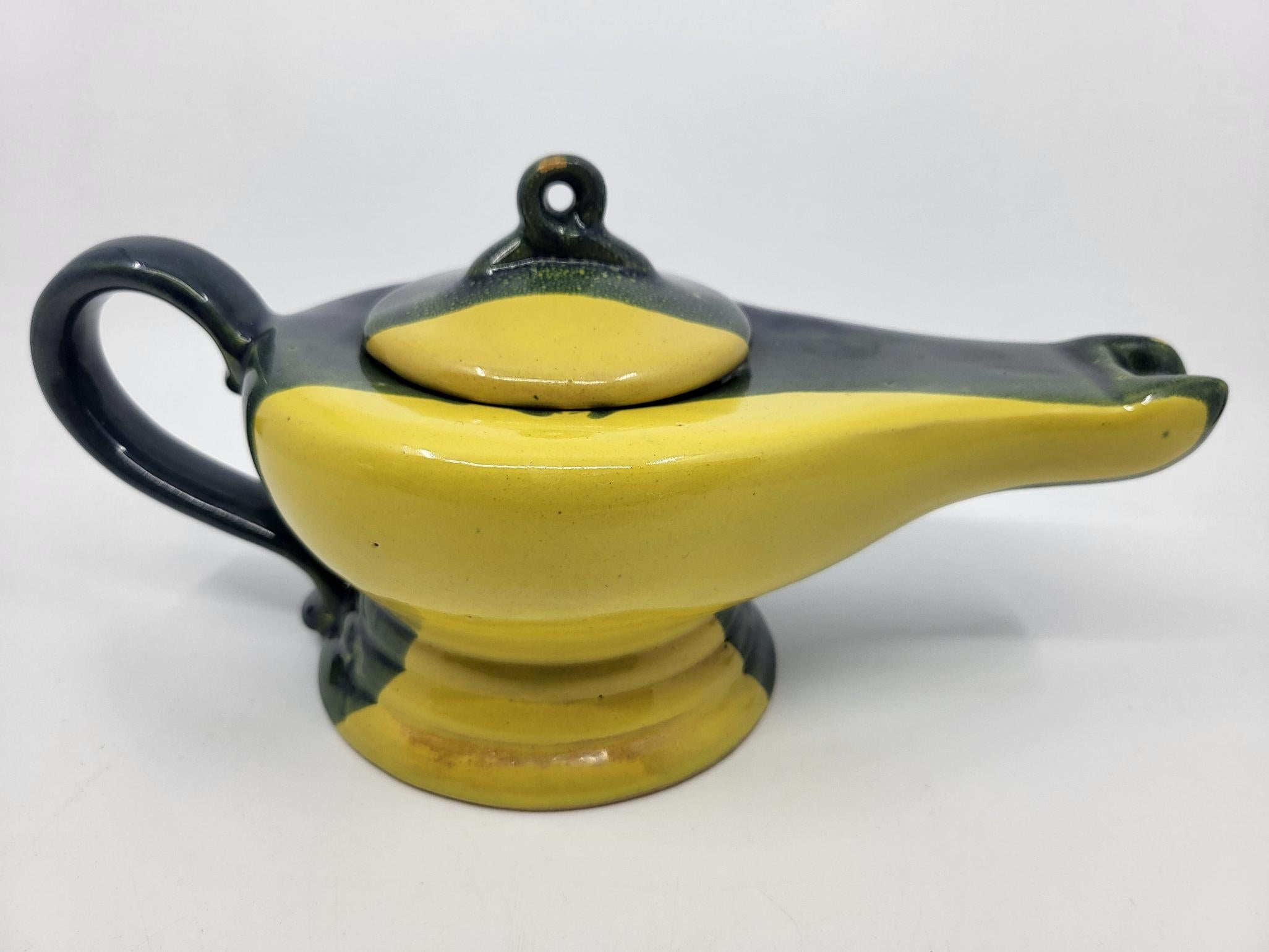 Diese wunderbare Schale aus französischem Céramique trägt ein zweifarbiges Design, das an ein Festspiel erinnert. Mit ihrer eleganten Form könnte man meinen, sie sei die Lampe von Aladdin, die ein Wunderwerk befreien soll. Auch wenn sie ein paar