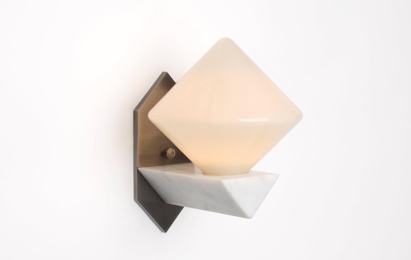 Originally inspired by Victorian balancing toys, the Themis 6 sconce juxtaposes the cone form of its hand blown glass diffuser with the triangular shape of its marble support bracket.