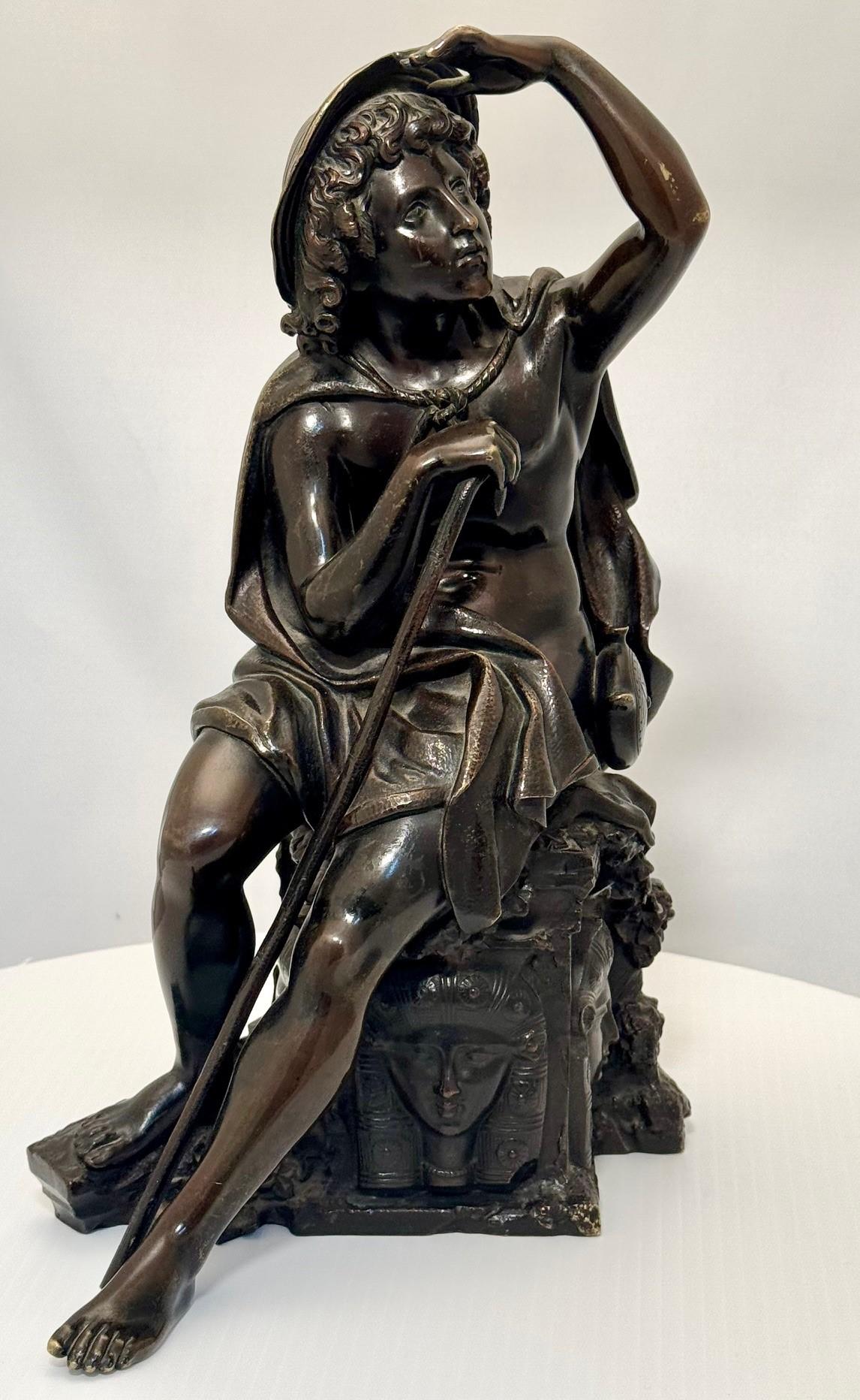 Questo bronzo è molto attraente e raffigura un giovane in viaggio che guarda in lontananza. An He ha un bastone con cappello da sole e una borraccia e siede su uno sperone roccioso (o forse una testa di pozzo) scolpito con ritratti in stile egiziano