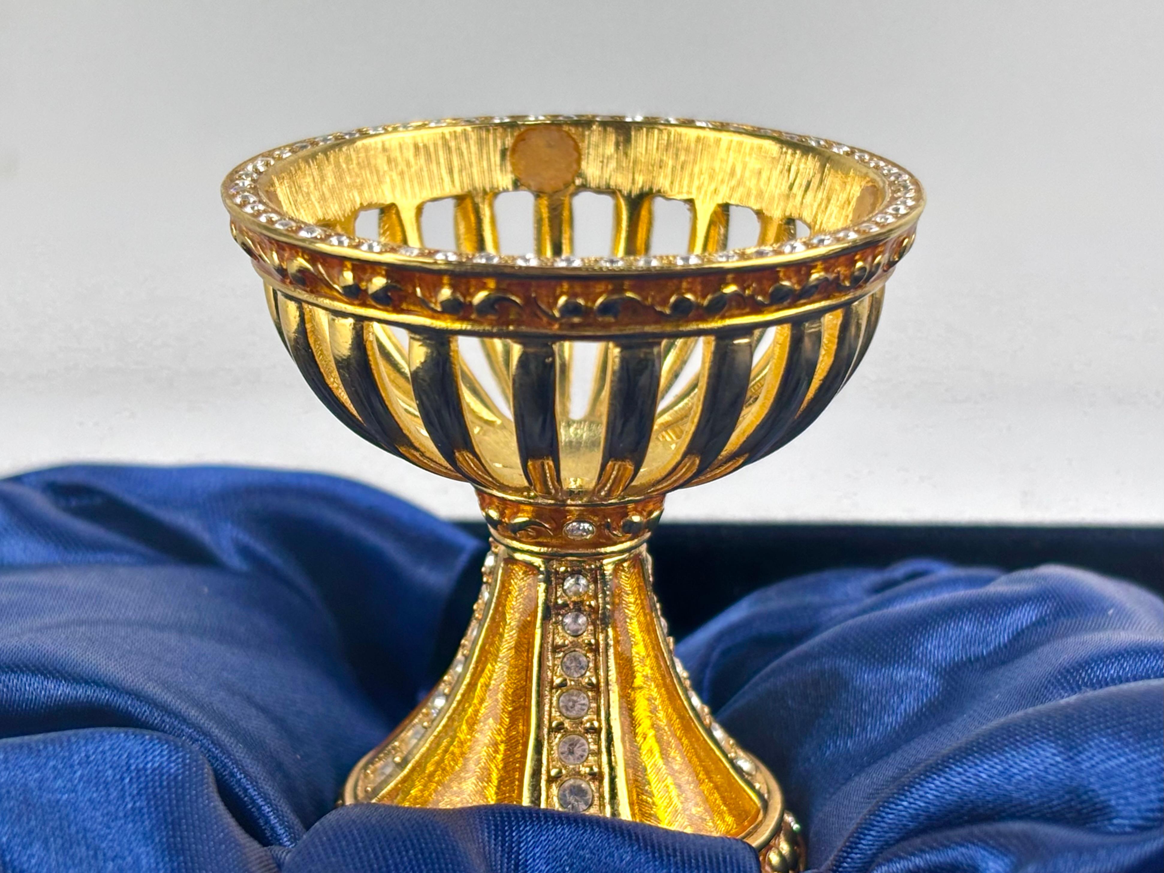 Interesante huevo de cristal de roca y bronce de la famosa marca Fabergé.

El soporte es de bronce y pedrerías

Va firmado en la base -Fabergé 8634-

Va con el certificado y su caja original.

Medidas huevo con soporte: 9 cm altura; 5 cm diámetro.