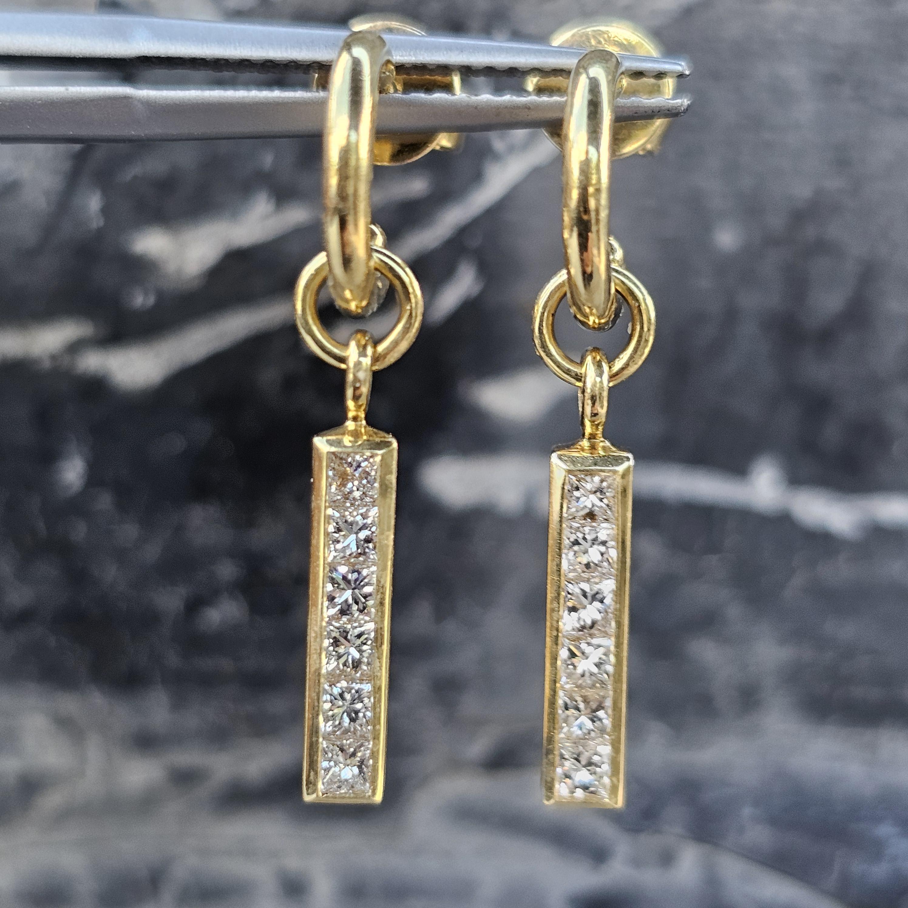 Rehaussez votre style avec ces boucles d'oreilles pendantes Theo Fennell. Confectionnée en or jaune 18k, chaque boucle d'oreille présente une barre verticale ornée de diamants blancs taille princesse, créant ainsi une esthétique épurée et moderne.