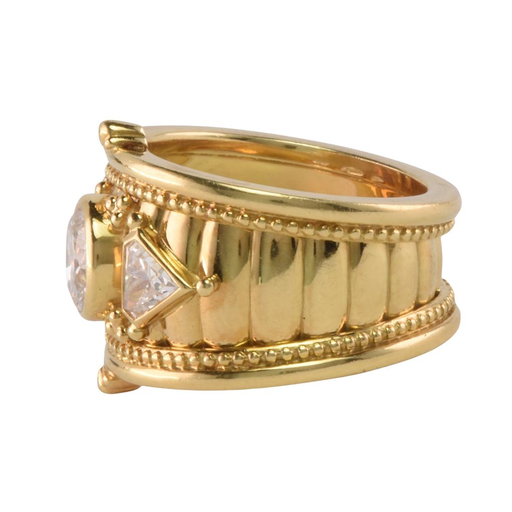 An extravagant, substantial Theo Fennell cocktail ring, hallmarked for the year 1992. 18 Carat yellow gold set with diamonds. The diamonds have an approximate weight. The principal round brilliant diamond 1.3 carats  and the 2 shield cuts 0.4 carats