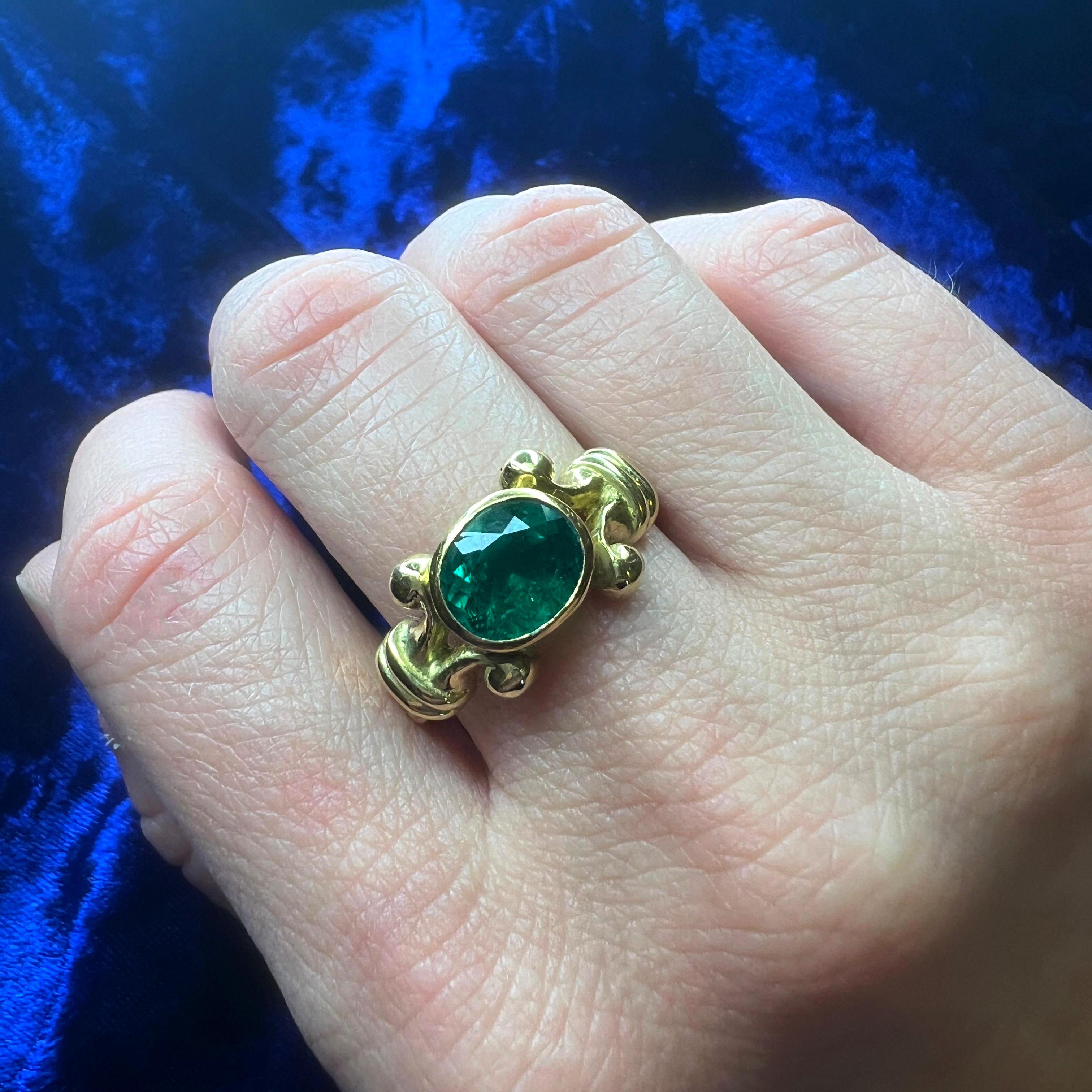 Dieser atemberaubende Ring des renommierten britischen Designers Theo Fennell ist aus 18 Karat Gelbgold gefertigt und zeigt einen natürlichen Smaragd im Ovalschliff mit einem Gewicht von etwa 1,50 Karat. Der leuchtend grüne Smaragd stammt aus