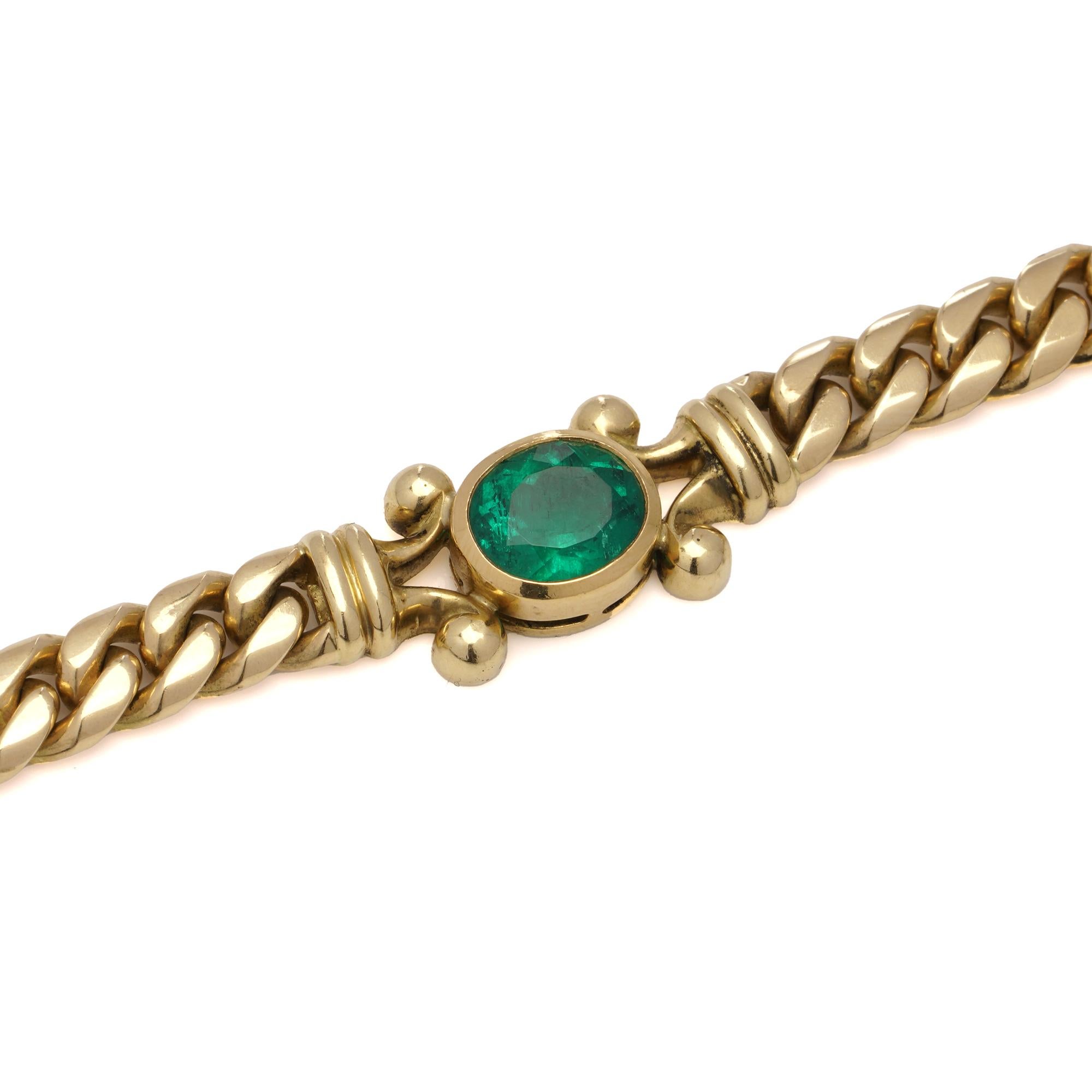 Theo Fennell 18kt gold and emerald curb link necklace.
The emerald is positioned at the centre of the necklace., with a collet setting within split shoulder mounts. 
Made in Italy, After 2000 
Hallmarked with Fennell, 750, and Italian assay office