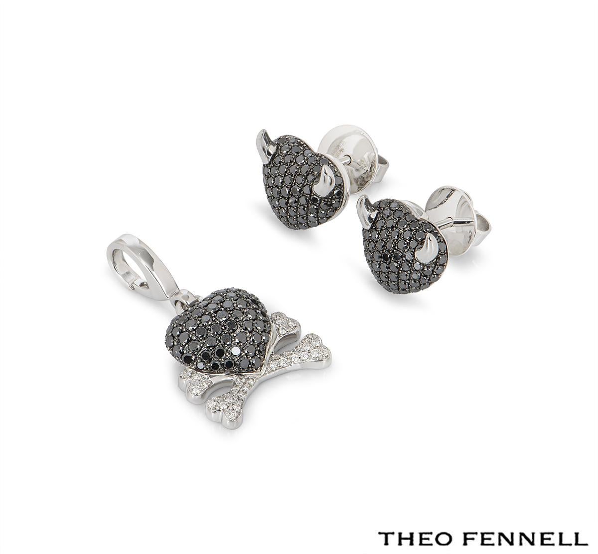 An 18k white gold Theo Fennell black and white diamond jewellery suite. The jewellery suite comprises of a charm and a pair of earrings. The charm features a heart and crossbones motif pave set with black and white round brilliant cut diamonds. The