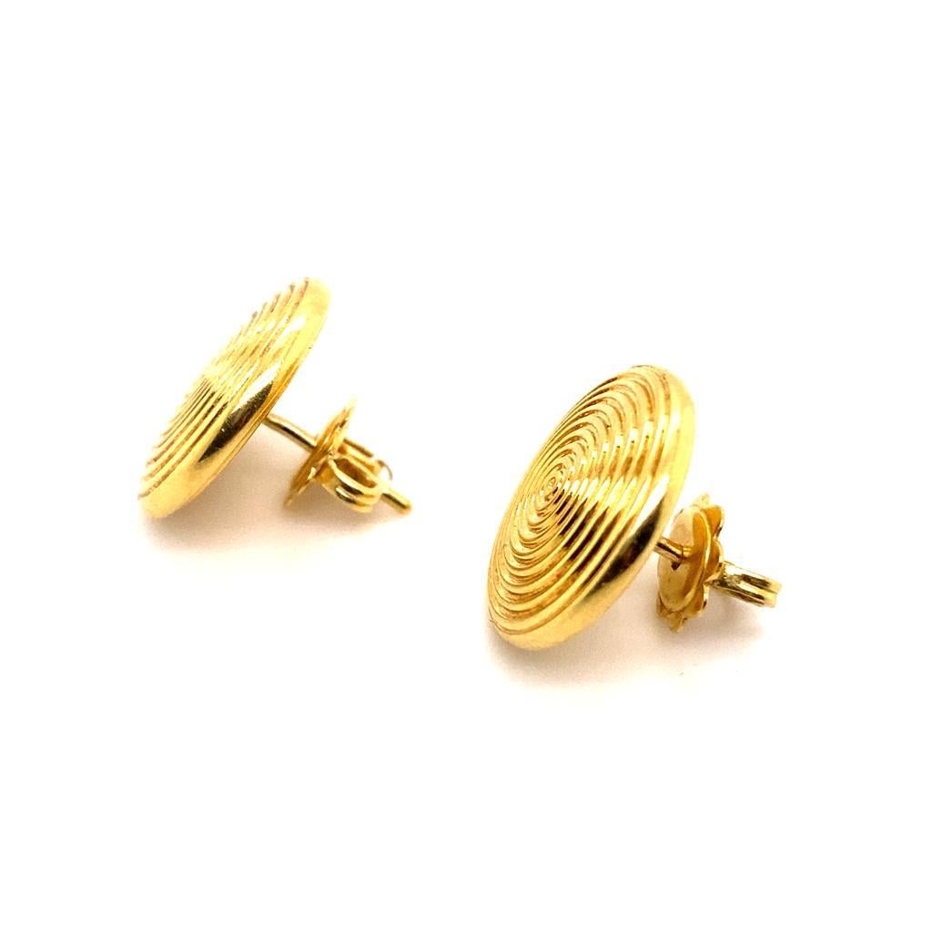 A pair of Theo Fennell circular 18 karat yellow gold earrings.

These elegant earrings feature a polished target design with circular engraving that reflects the light, shining beautifully when worn on the ear making them ideal for both daytime and