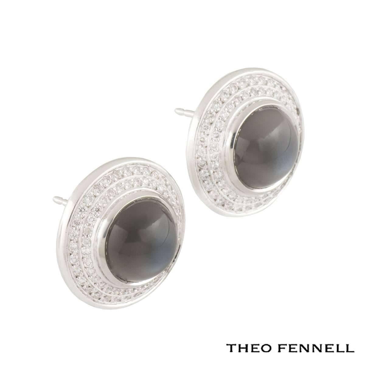 An 18k white gold Theo Fennell diamond and quartz jewellery suite. The jewellery suite comprises of a ring and a pair of earrings. The dome shaped ring is set to the centre with a cabochon cut grey smokey quartz weighing approximately 12.00ct,