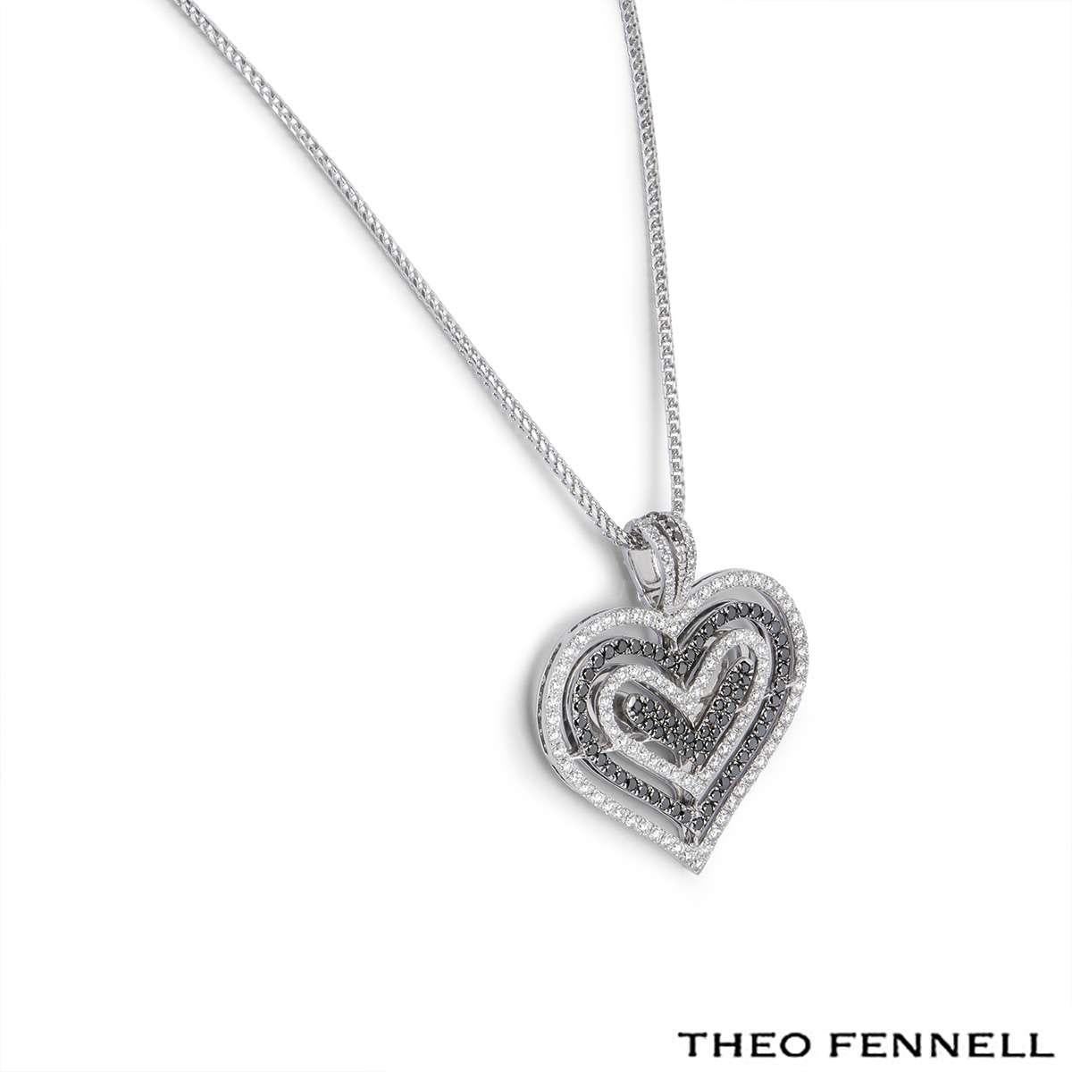 A beautiful 18k white gold Theo Fennell diamond pendant. The pendant comprises of an open work design with 4 hearts. Each heart has round brilliant cut diamonds in a pave setting alternating with black diamonds and white diamonds. There are 77 black
