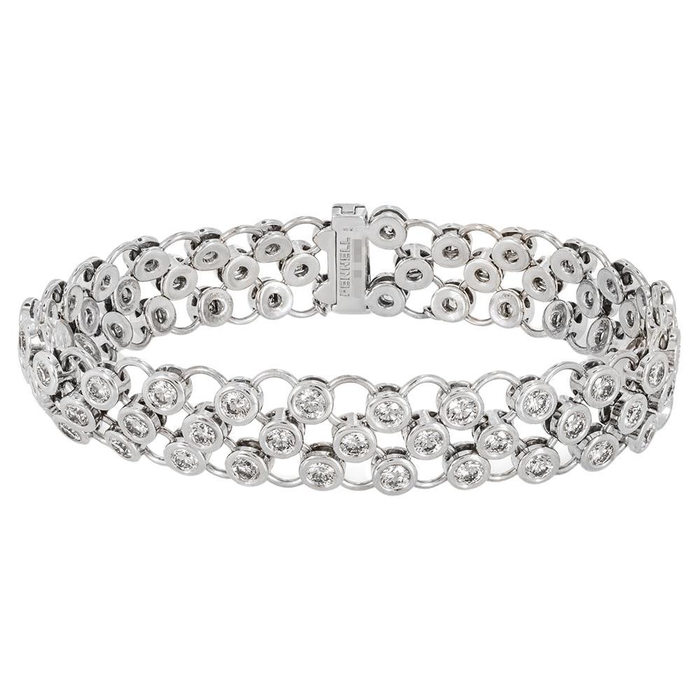 A gorgeous 18k white gold diamond bracelet by Theo Fennell from the Slinky collection. The bracelet consists of a three-row mesh design with 75 diamonds, evenly set throughout. The bezel set round brilliant cut diamonds have an approximate total