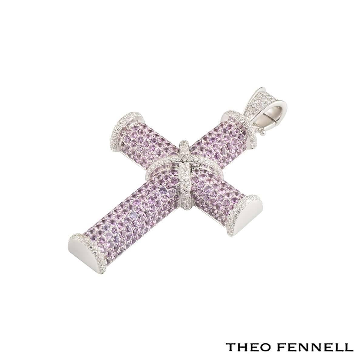 A stunning 18k white gold Theo Fennell pink sapphire and diamond cross pendant. The pendant comprises of a cross motif, fully pave set with round brilliant cut diamonds on the 4 edges and is accentuated by a diamond set 'X' design set to the centre