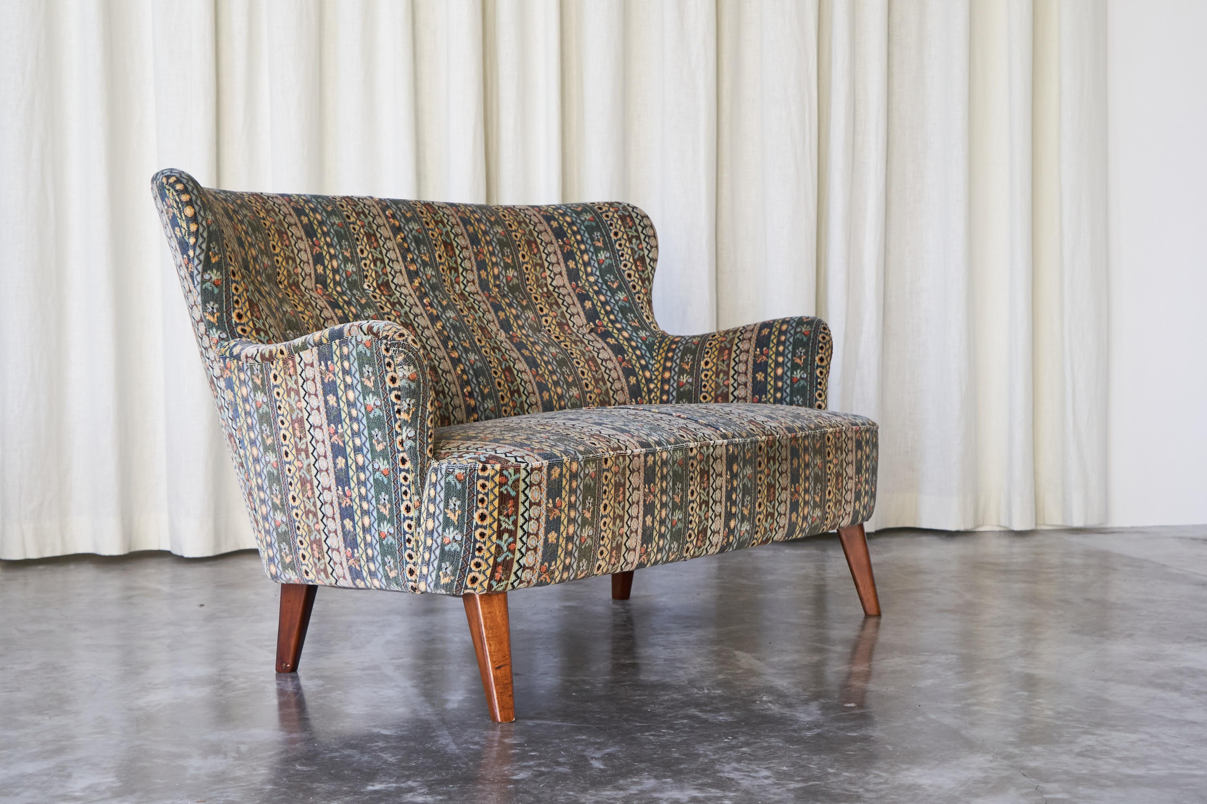 This is a wonderful sofa designed by Theo Ruth for Wagemans & van Tuinen / Artifort, made in 1956. 

The design of this sofa is classic mid-century and Scandinavian in style, but really comes to life due to the fantastic colorful upholstery. This