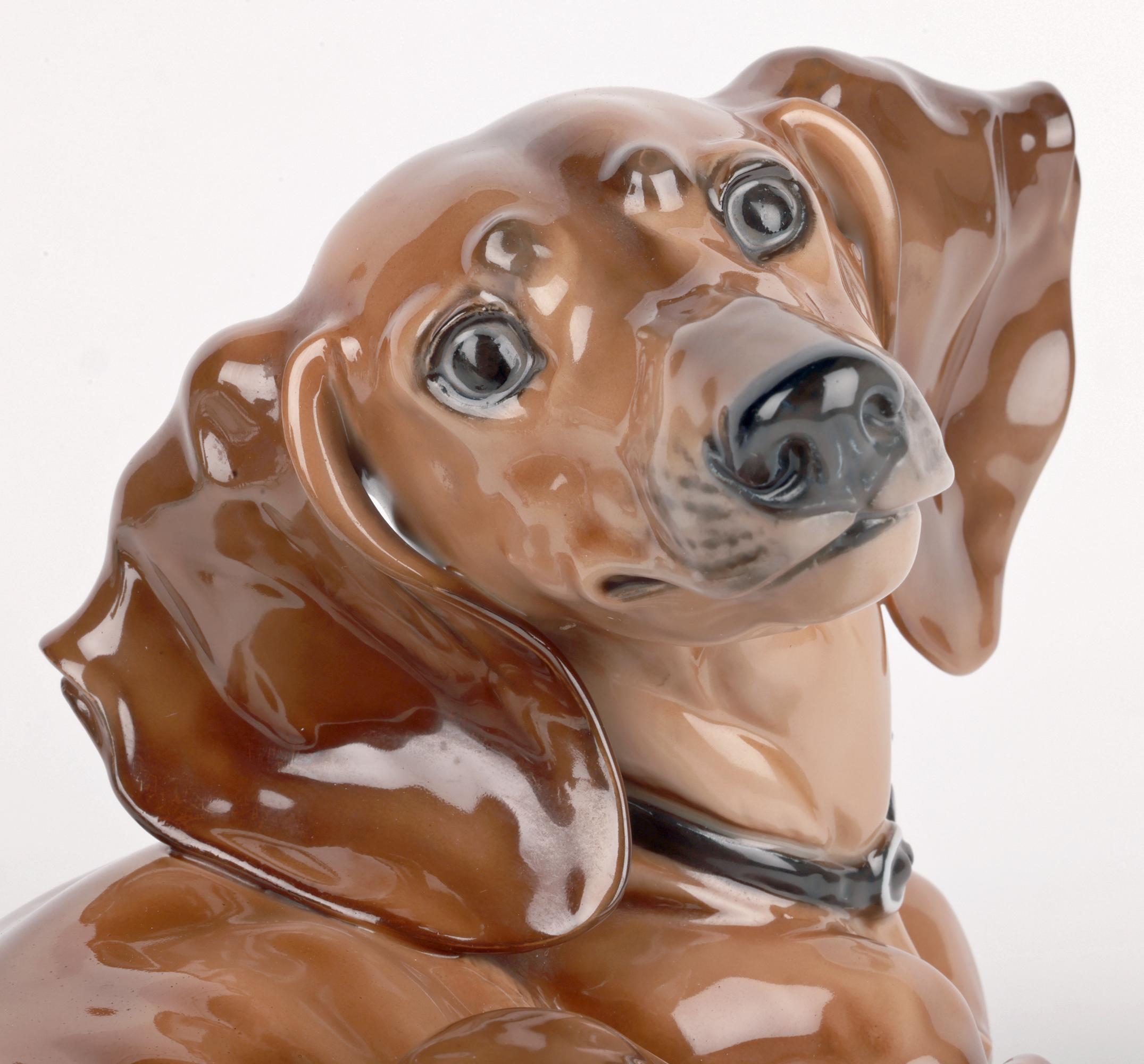 Rare et exceptionnelle figurine en porcelaine artisanale de Rosenthal représentant un teckel, modelée par le professeur Theodor Karner (allemand, 1884-1966) et datant d'environ 1937. Le teckel est représenté en position couchée, une patte tendue