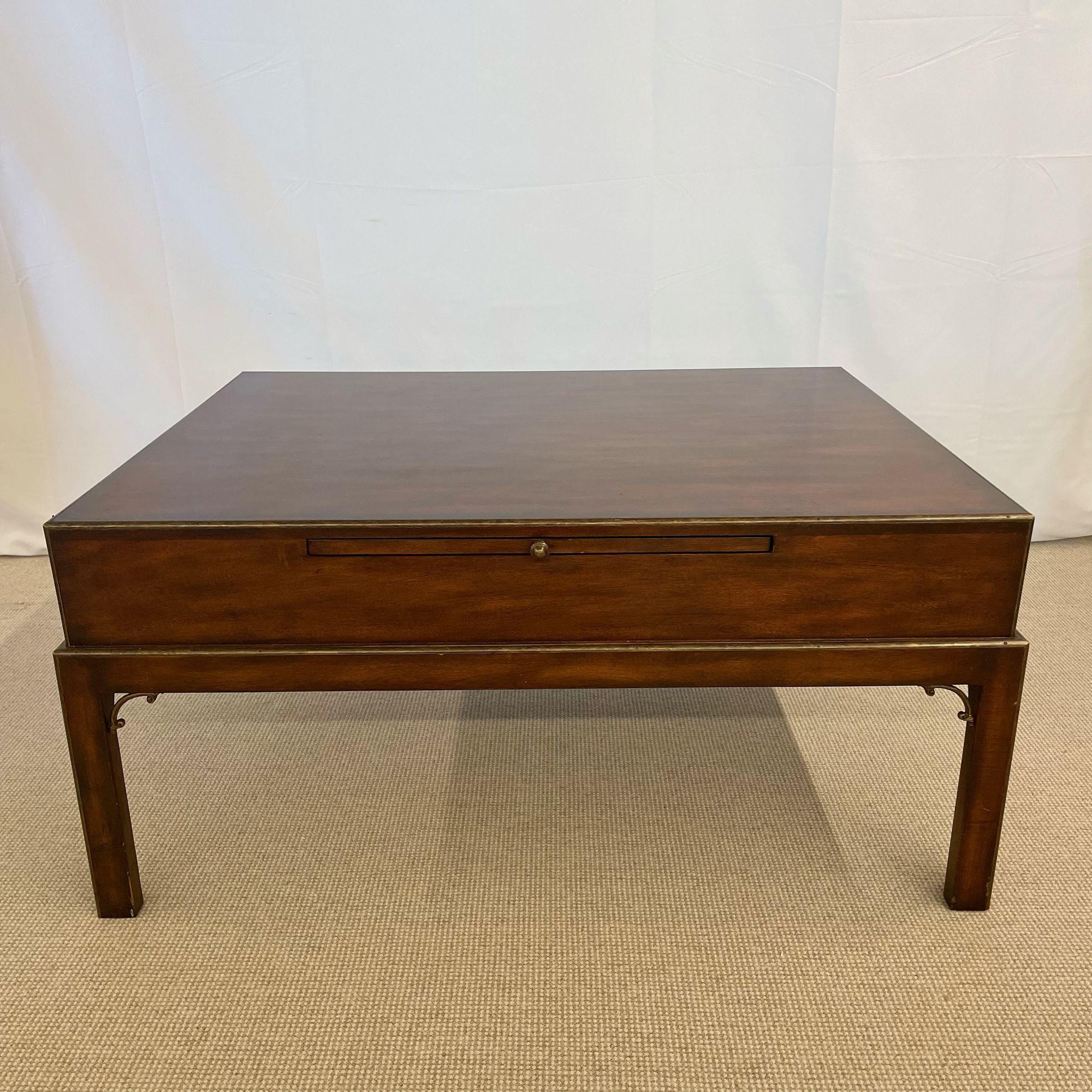 Theodore Alexander Campaign Style Square Coffee Table, Mahogany and Brass
 
This stylish coffee or cocktail table has a drawer on each end and a pull out tray on each of the opposing ends. Good Condition. 
 
 20.25H x 43Wx33D
 