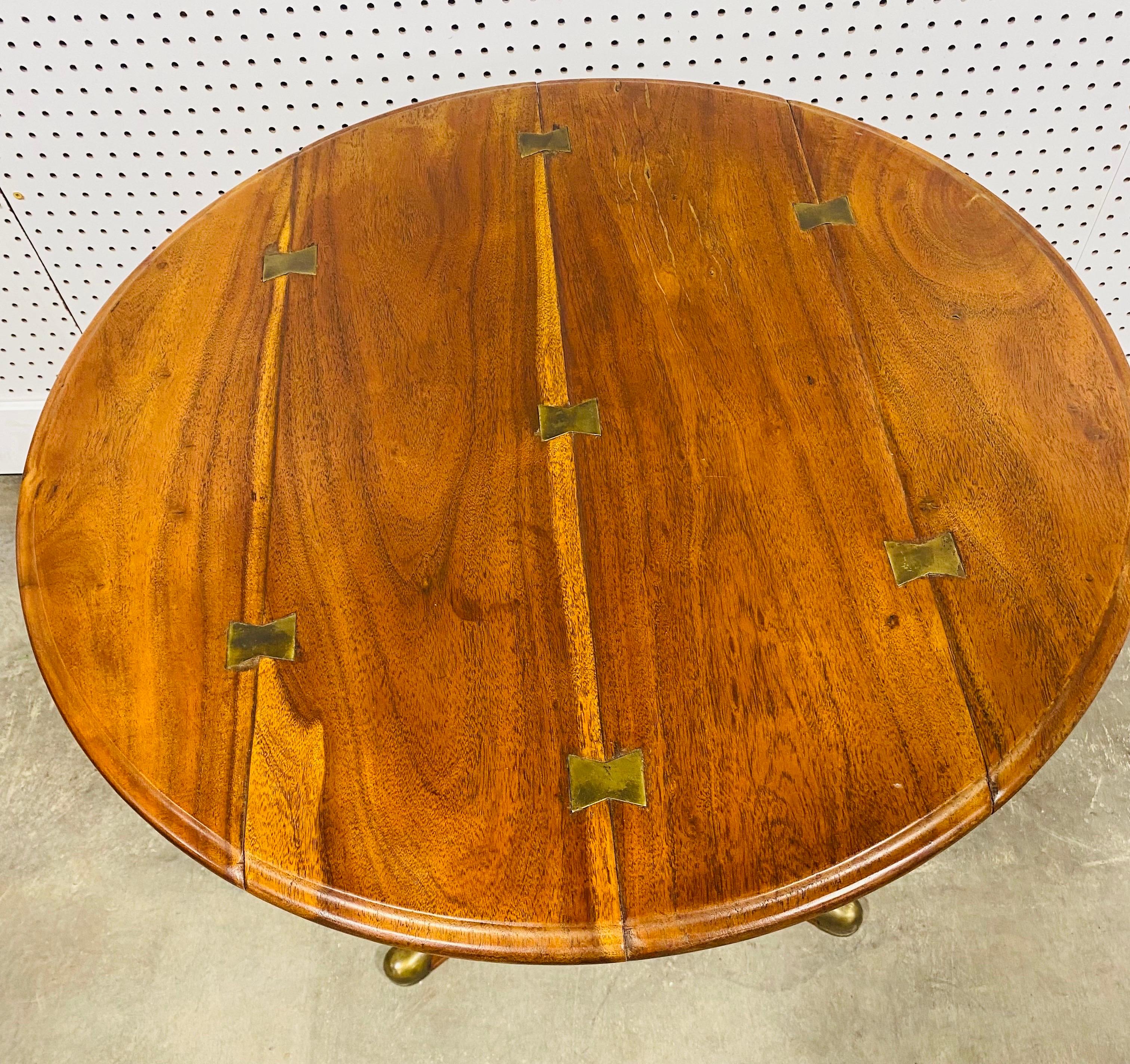 This is a walnut and brass handcraft classical style side table by Theodore Alexander. This table has a classic queen ann leg with brass accents on the end of each foot. The table has brass butterfly details to the top. This Theodore Alexander table