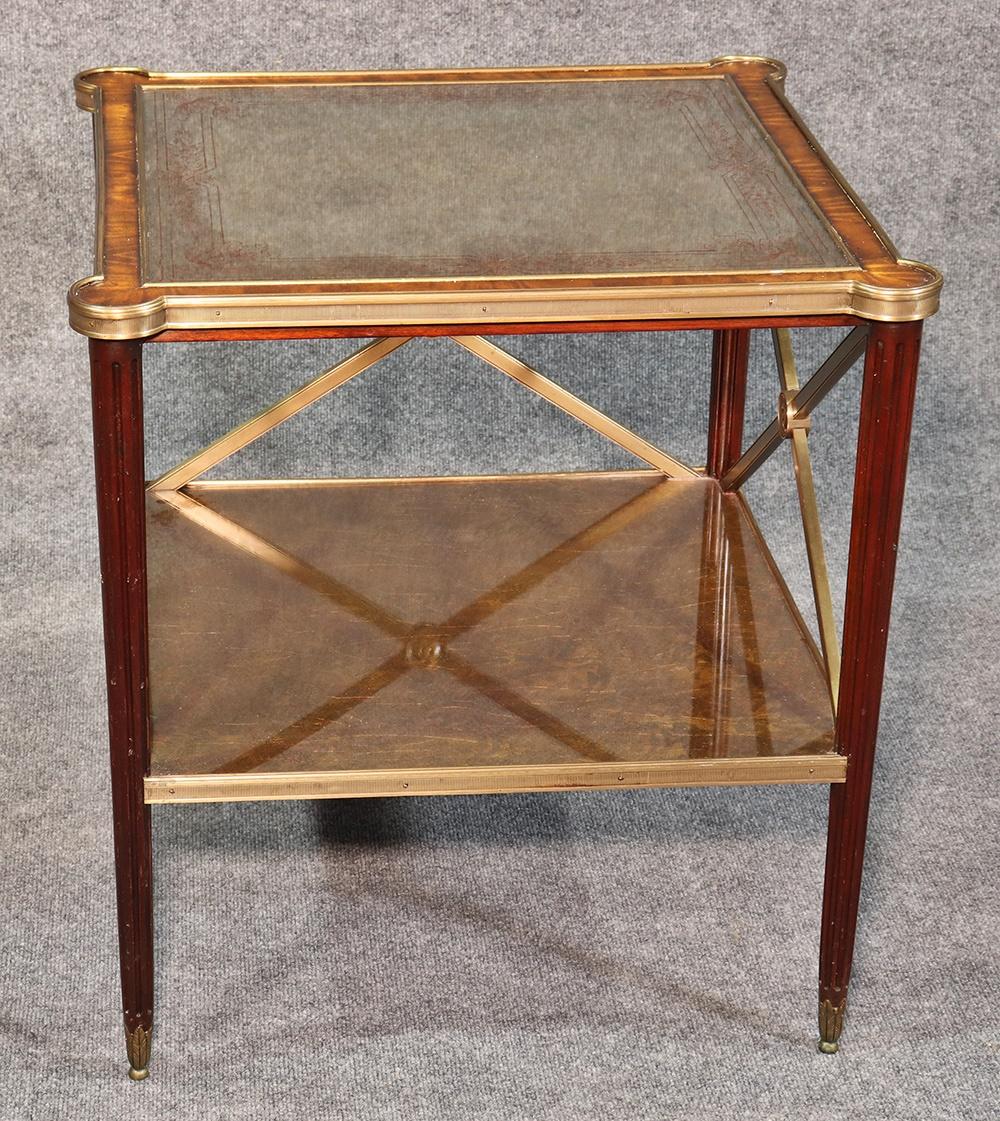 This is a gorgeous Theodore Alexander Directoire style end table with an églomisé gold leaf under glass top with superb quality bronze mounts everywhere. Perfect for use as a small center table in a foyer or anywhere else in your home.