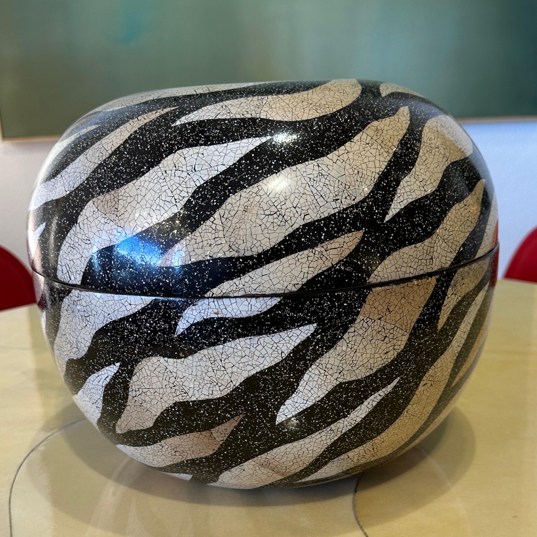 This is a stunning lidded box manufactured in Vietnam for Theodore Alexander. The box features eggshell lacquer exterior in a gorgeous zebra stripe design in colors of off white, taupe, light brown and black. The interior is a solid black lacquer.