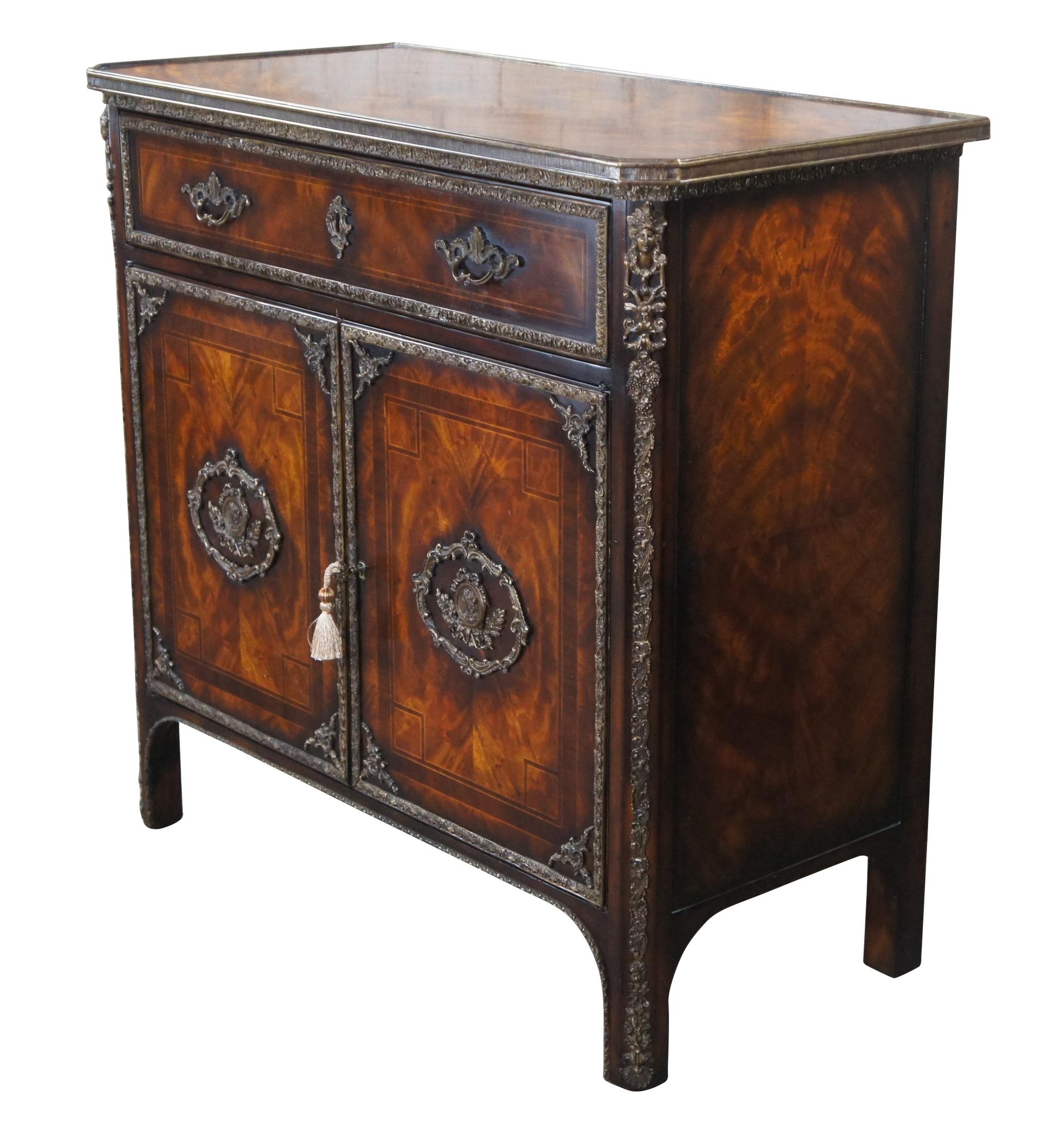 Theodore Alexander Althorp Console Flourish Cabinet / Console Table

The Flourish dining room side cabinet is a Louis XVI style flame mahogany ormolu mounted and banded cabinet with a rectangular brass bound top with canted corners above a long