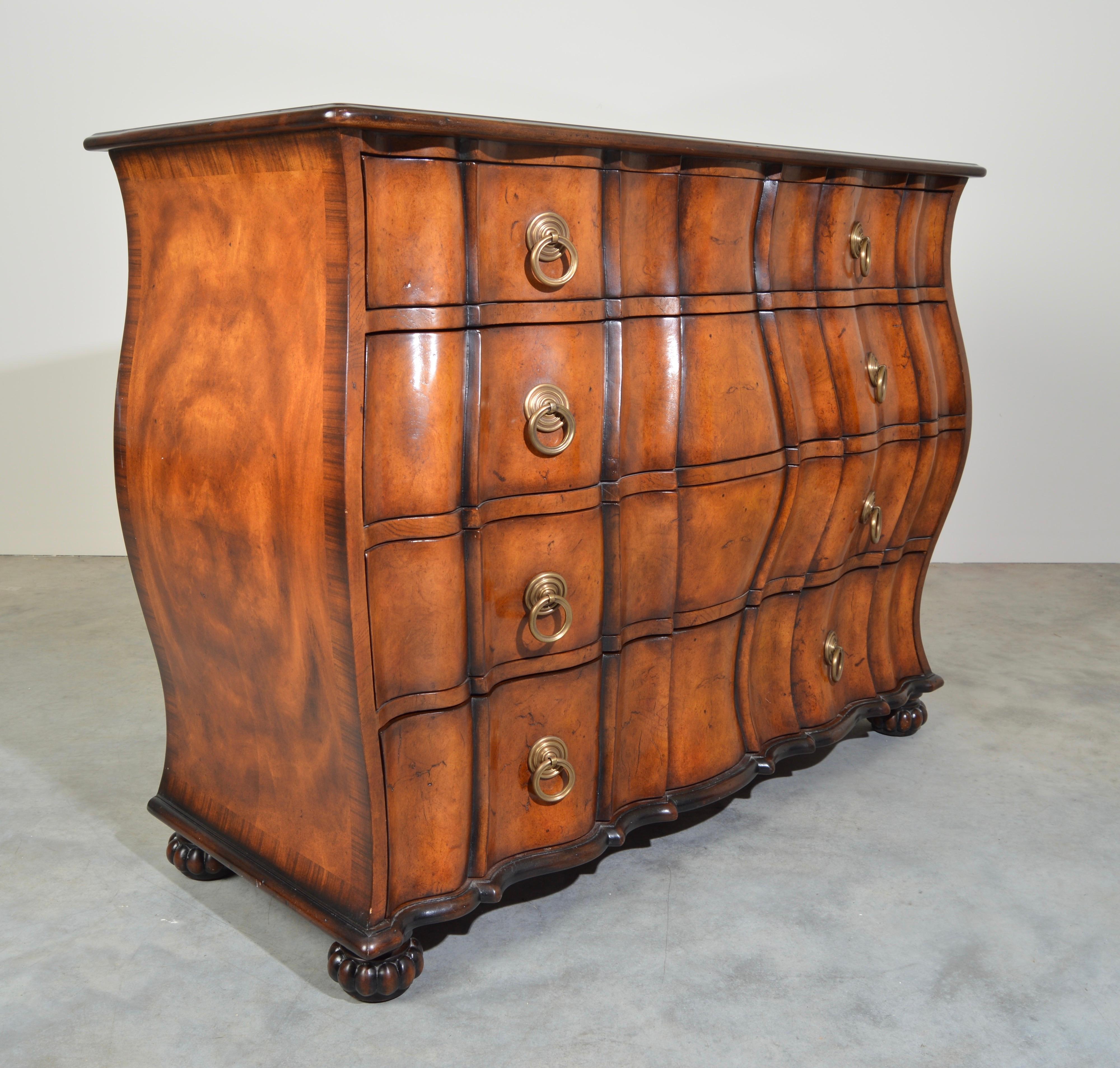 An ash burl serpentine chest of drawers having four sculptural wavy front drawers with brass drop handles, panelled sides, with carved cannonball legs. 
The original French Provincial.
Outstanding condition having been gently used and well