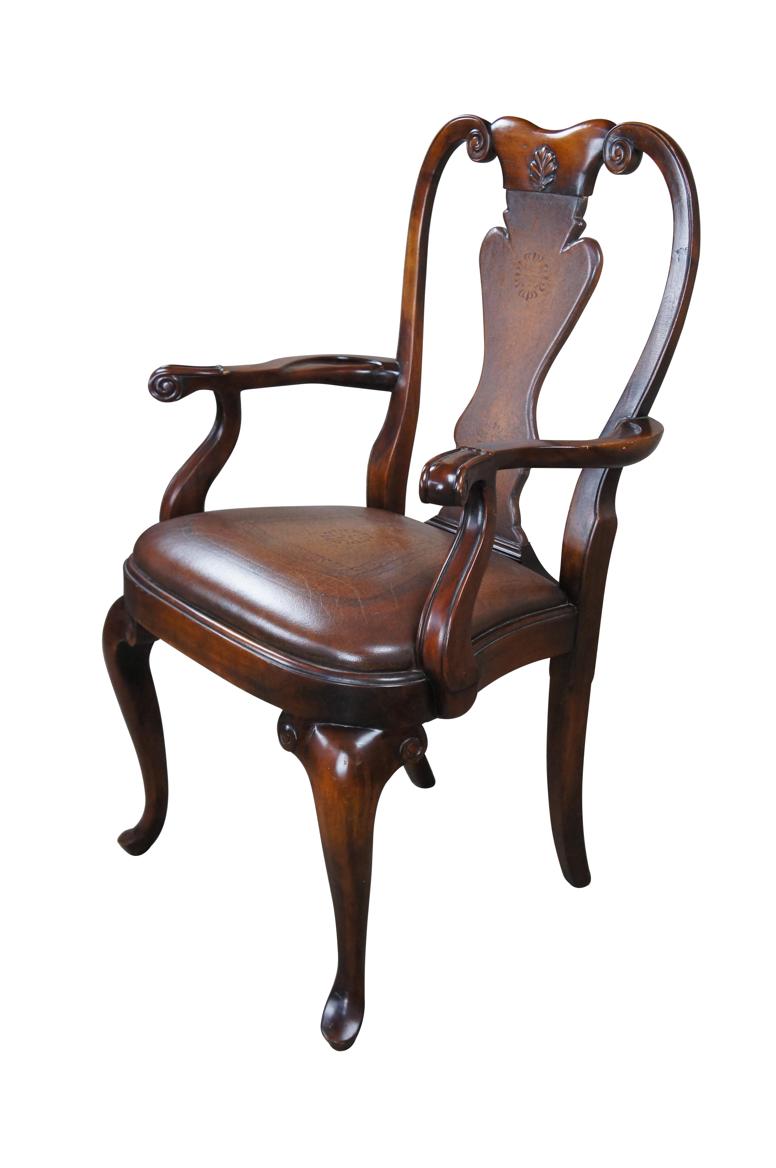 A stately arm chair by Theodore Alexander. Modeled after a traditional Georgian Period Queen Anne chair. Features a mahogany frame with scrolled and carved crest rail over a brown tooled leather vase shaped splat, matching seat and cabriole