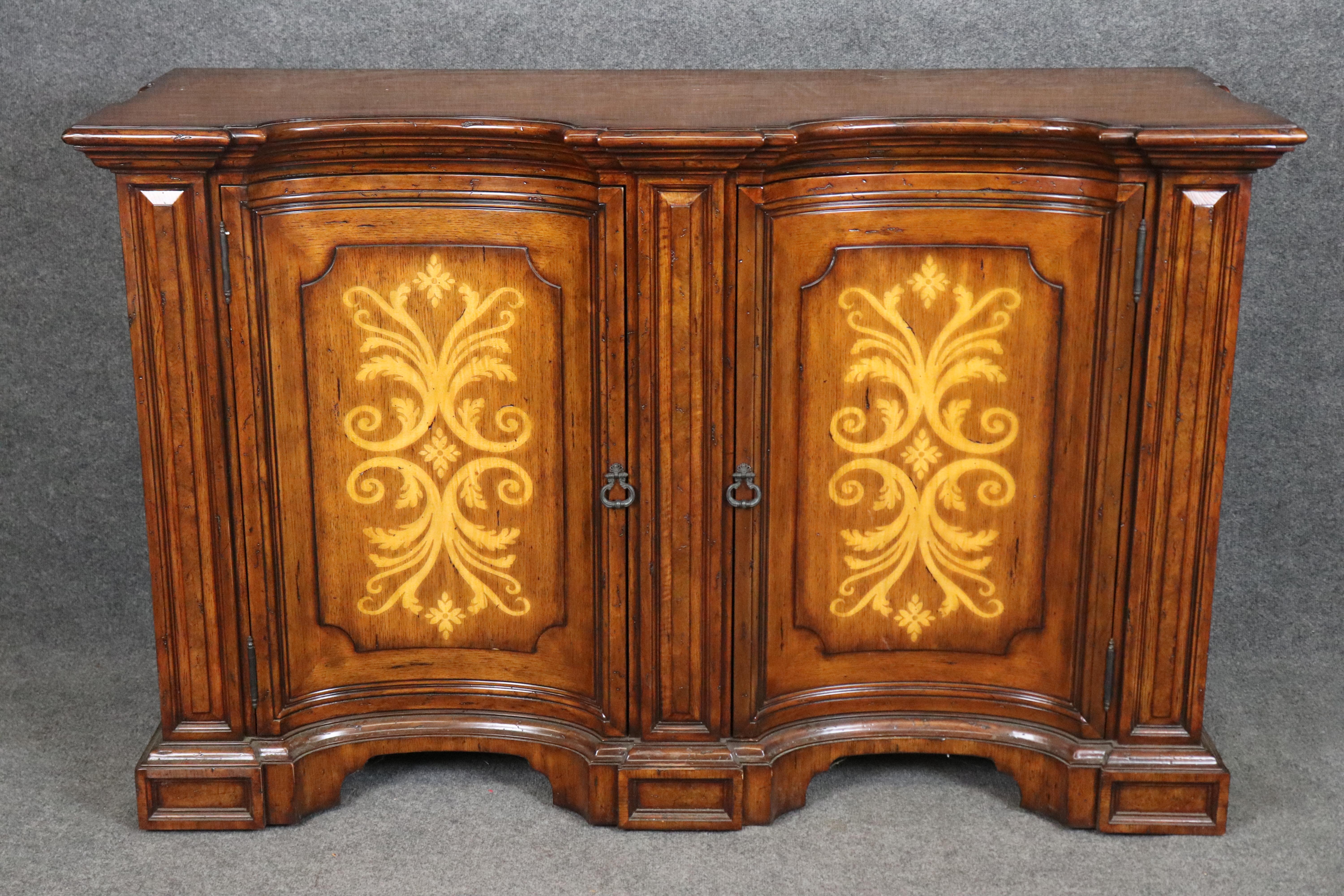 Dimensiones - Al: 40 1/4 pulg An: 62 pulg D: 22 pulg 

Este aparador de estilo georgiano con acabado en nogal de Theodore Alexander, un ejemplo excepcional de artesanía fina y diseño atemporal, es una declaración de elegancia, funcionalidad y