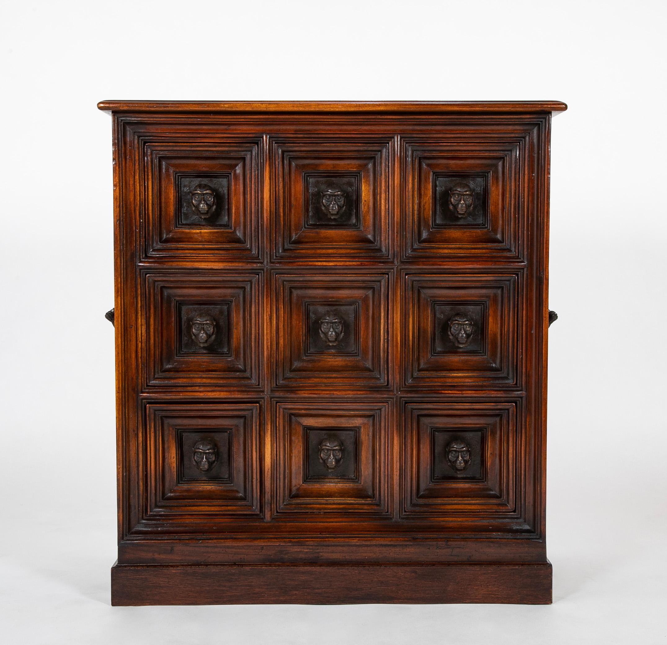 An amusing leather panel chest on stand, with nine bronze monkey head handled drawers, by Theodore Alexander, after the original 19th century Italian. This is a real conversation piece, amusing, whimsical, and also a beautifully made solid credenza