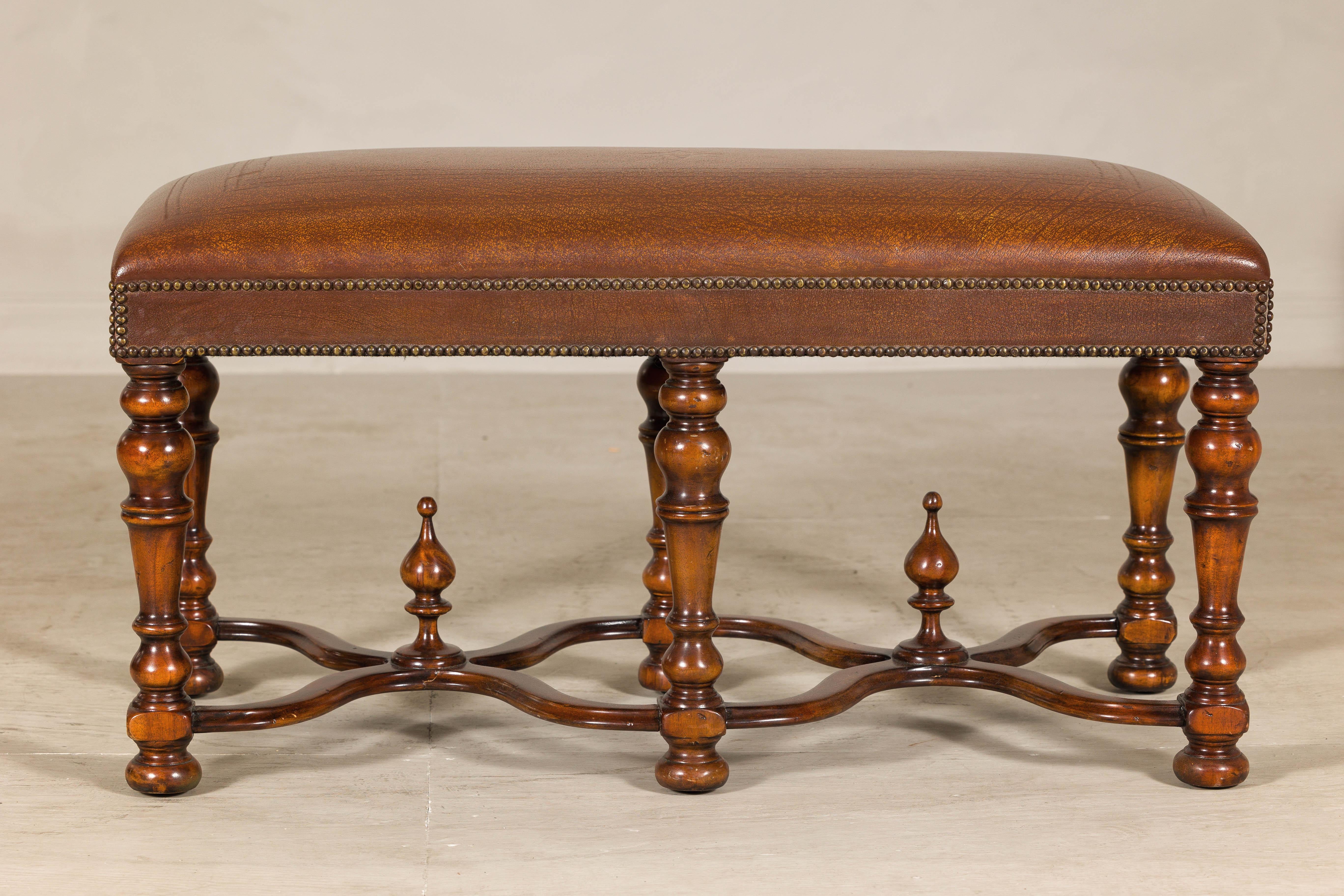 Banc de style Louis XIII par Theodore Alexander, qui met en valeur le raffinement de l'artisanat et l'élégance européenne classique. Reposant sur six pieds robustes et tournés, ce banc en bois dur offre une présence substantielle mais gracieuse. Les
