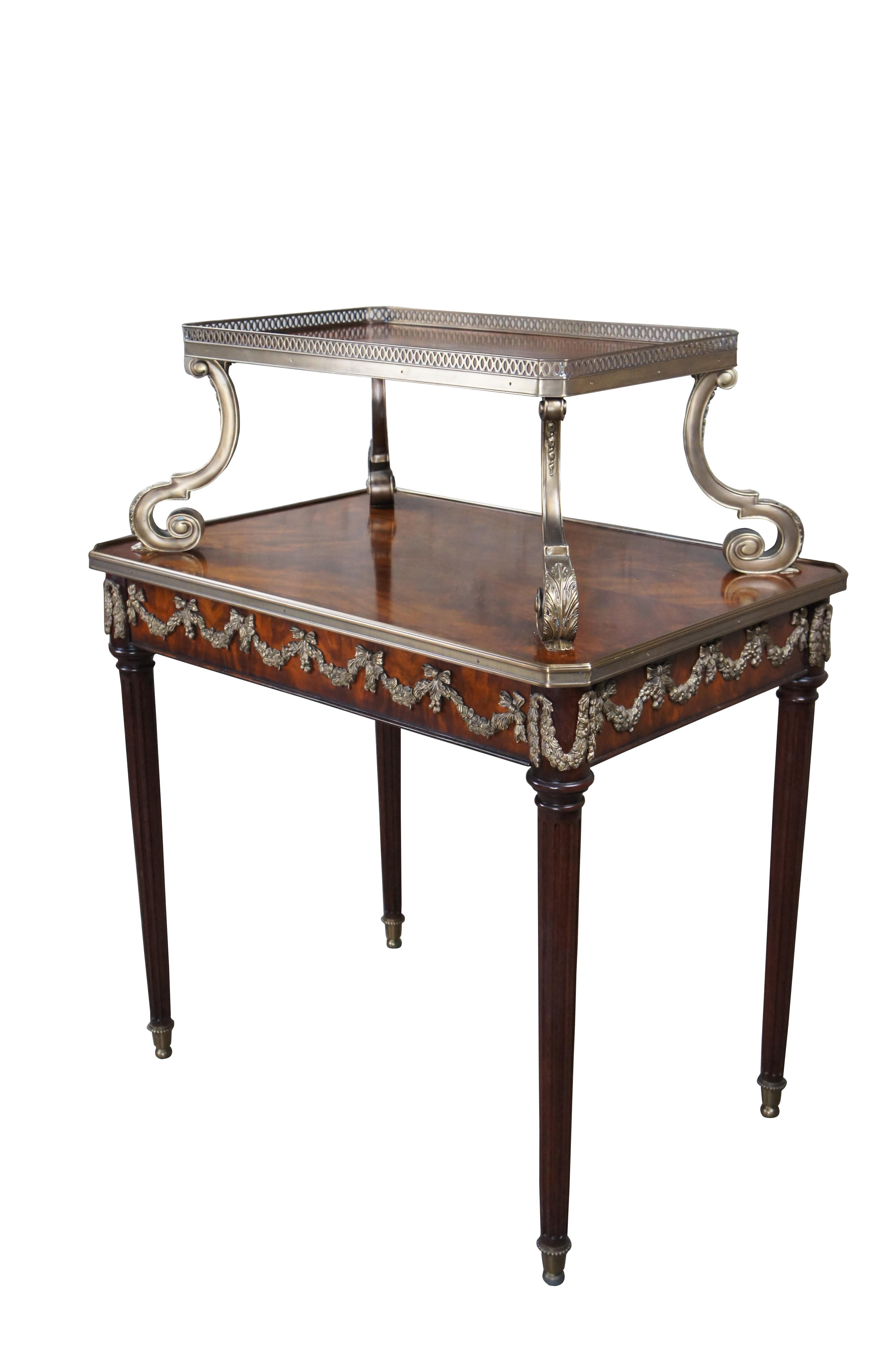 Late 20th century Louis XVI table by Theodore Alexander. Part of their Replica Collection. The original dating to 1780. A two tier crotch mahogany frame with drawer, the pierced brass galleried tier on leaf vast brass scroll supports trailing to the