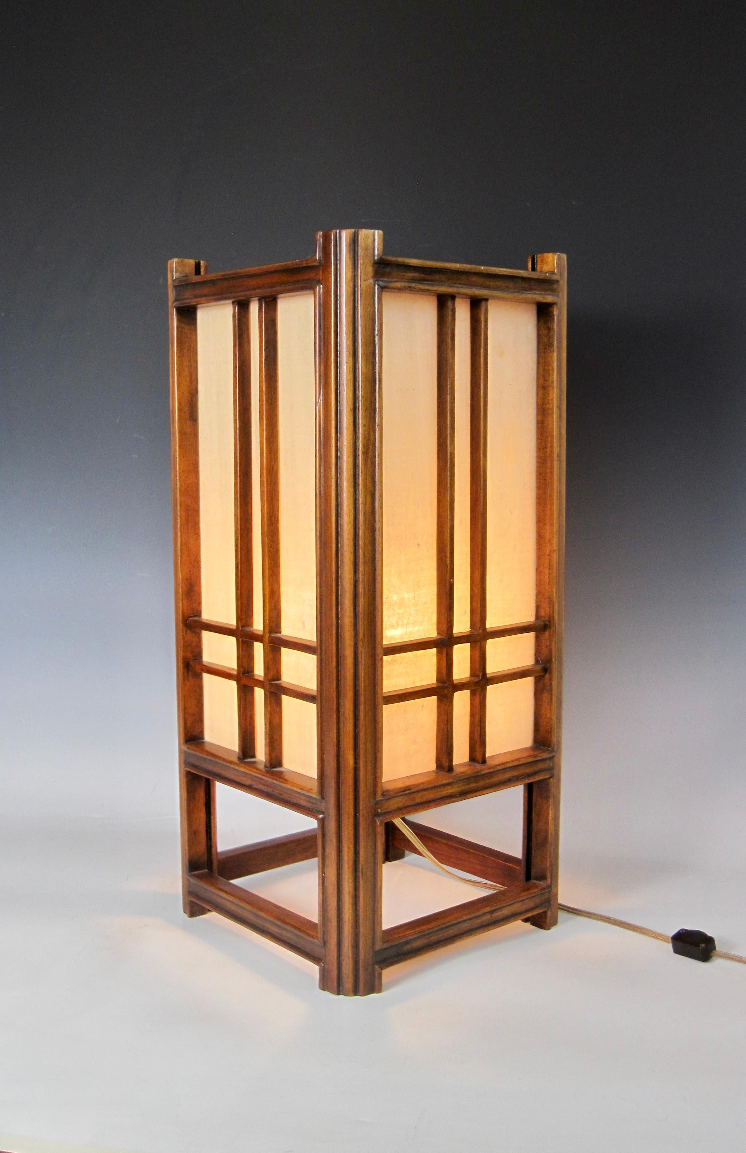 A Shoji style lantern lamp by Theodore Alexander formally of Maitland Smith. Hardwood frame with four rice paper double sided glass panels and single bayonet bulb holder. Photographed with a 95 watt soft white light bulb. The on / off inline rotary