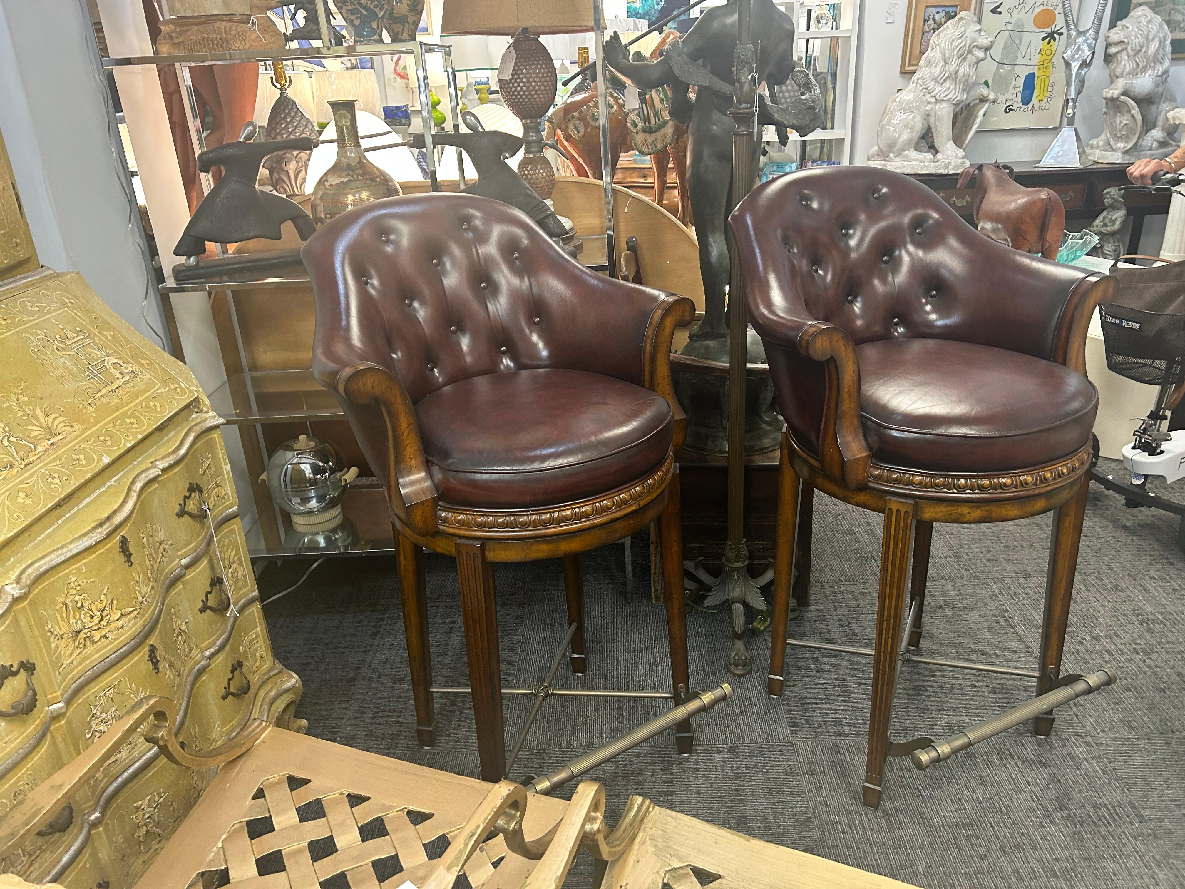 Paire de tabourets de bar Vintage, Theodore Alexander, à dossier bombé, avec accoudoirs évasés, 12 boutons touffetés, en cuir fin bordeaux.  Les cadres sont en acajou avec de jolis détails sculptés... dans un état presque inutilisé... Ces tabourets