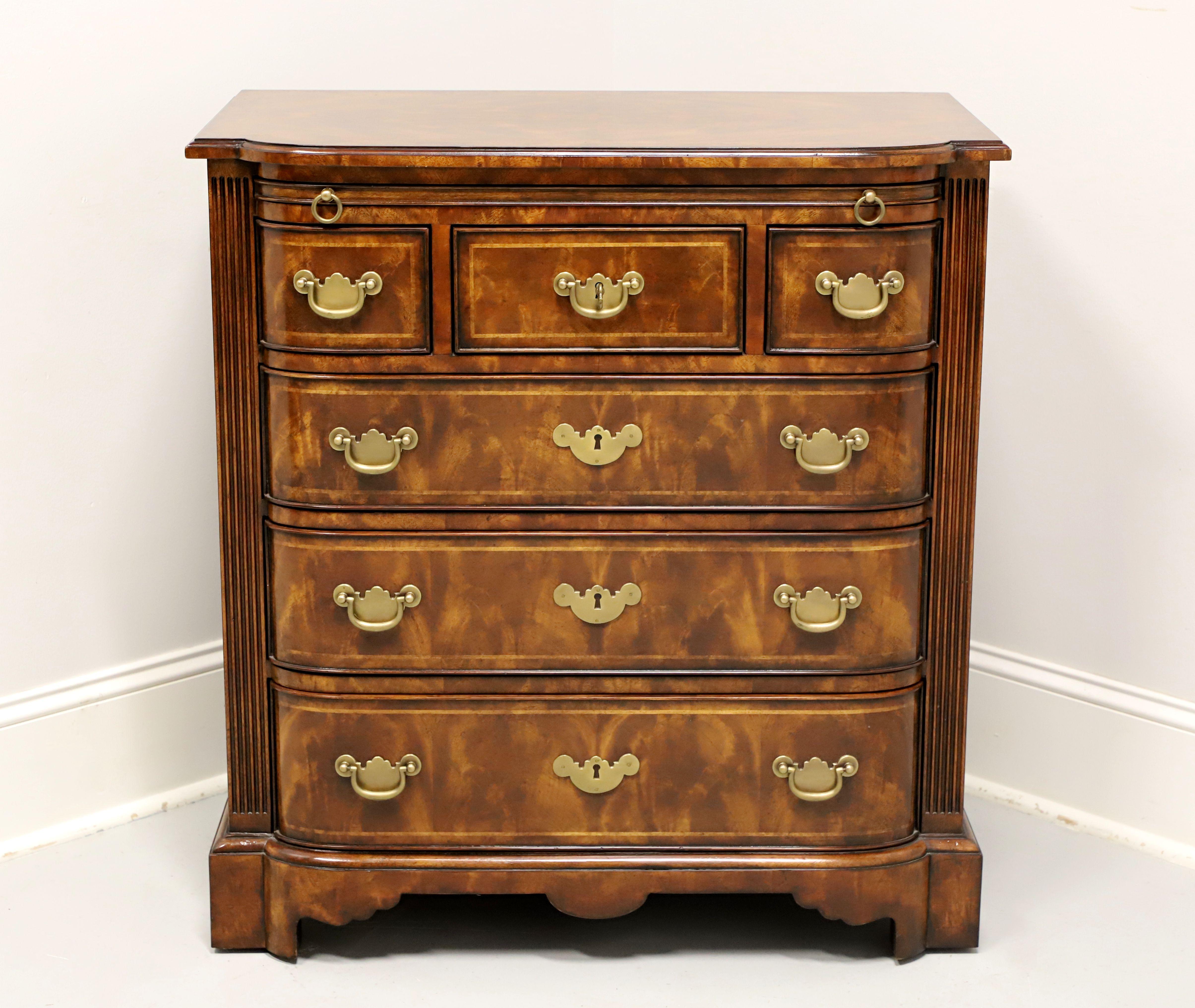 A Chippendale style bachelor chest by Theodore Alexander, from their Rep•li•ca Collection. Burl walnut with brass hardware, bowfront shape, banded bevel edge top, pull-out brushing slide, banded drawer fronts, column-like front corners, and bracket