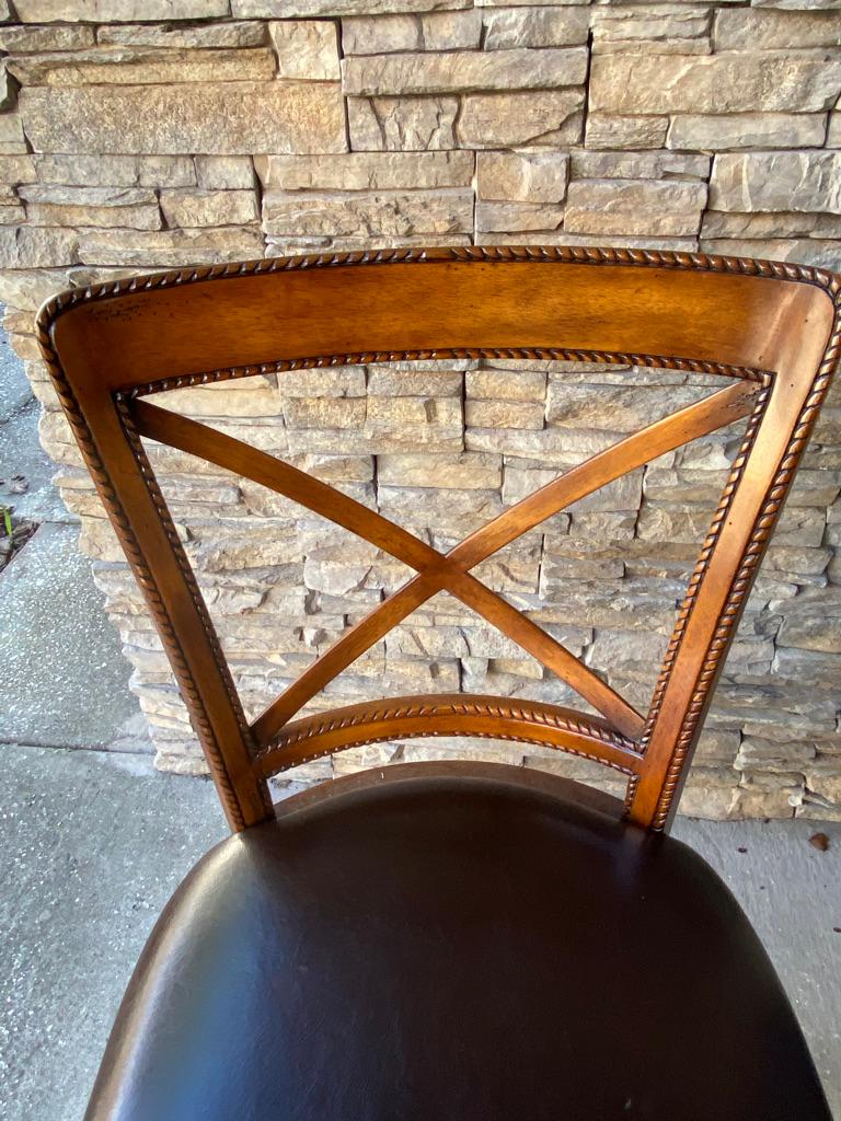 Theodore Alexander walnut side chair with dark brown leather seat. Hand carved cording design trims the back, legs and seat.