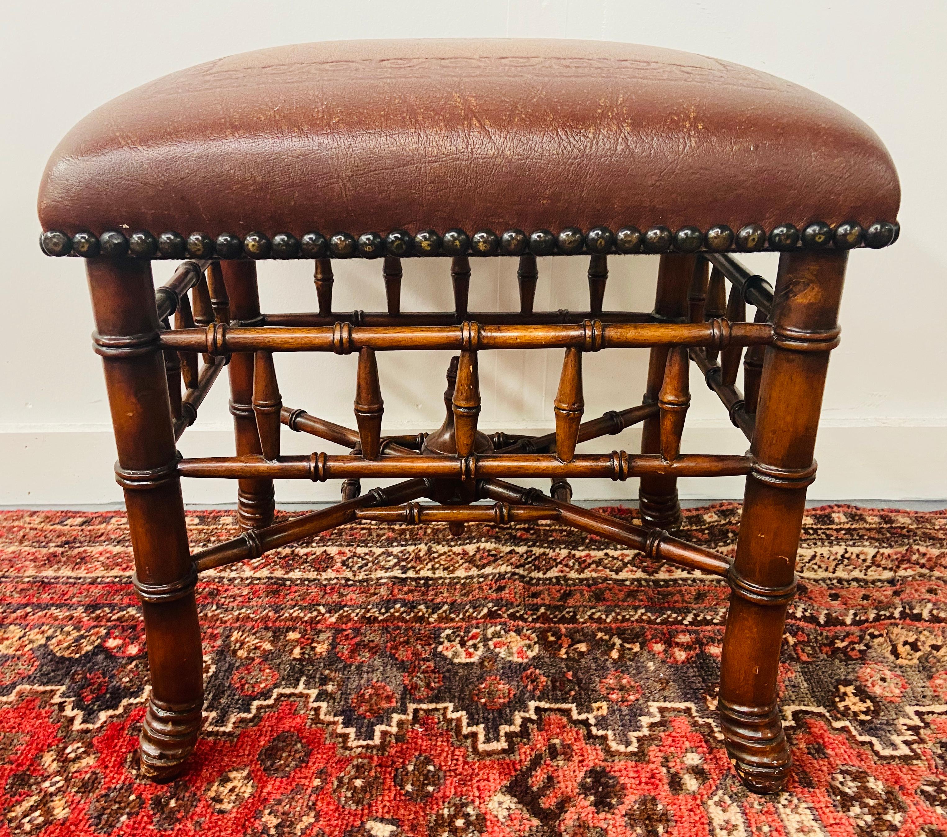 A gorgeous Theodore Alexander hand carved stool or ottoman featuring bamboo base turned legs and wavy 