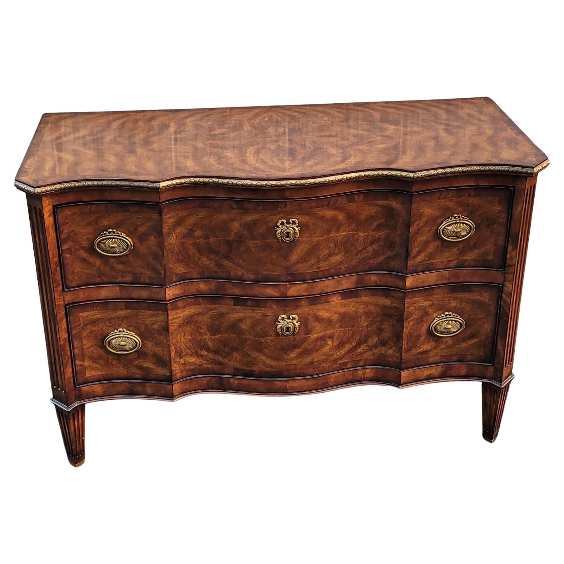 A rare, exquisite Theodore Alexander The India Silk collection Serpentine flame Mahogany & Giltwod Commode chest of drawers in excelent vintage condition. 
Cast brass drawer pulls and gilt wood ornate top edges. Flawlessly functionning mahogany