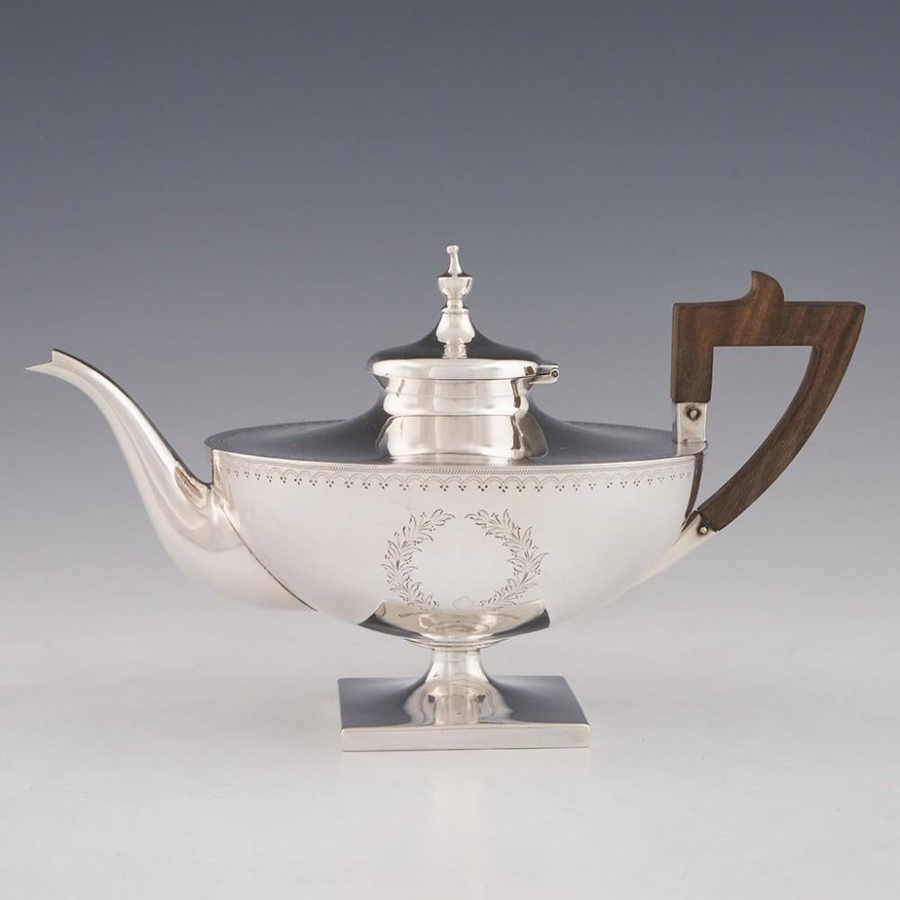 A Theodore Starr sterling silver bachelors tea set. Swag and pendant borders with foliate cartouche. Square pedestal feet with original walnut handle. 
The teapot is market 3/4 pint. 
489 grams (approximately 15 troy ounces)
All pieces marked on