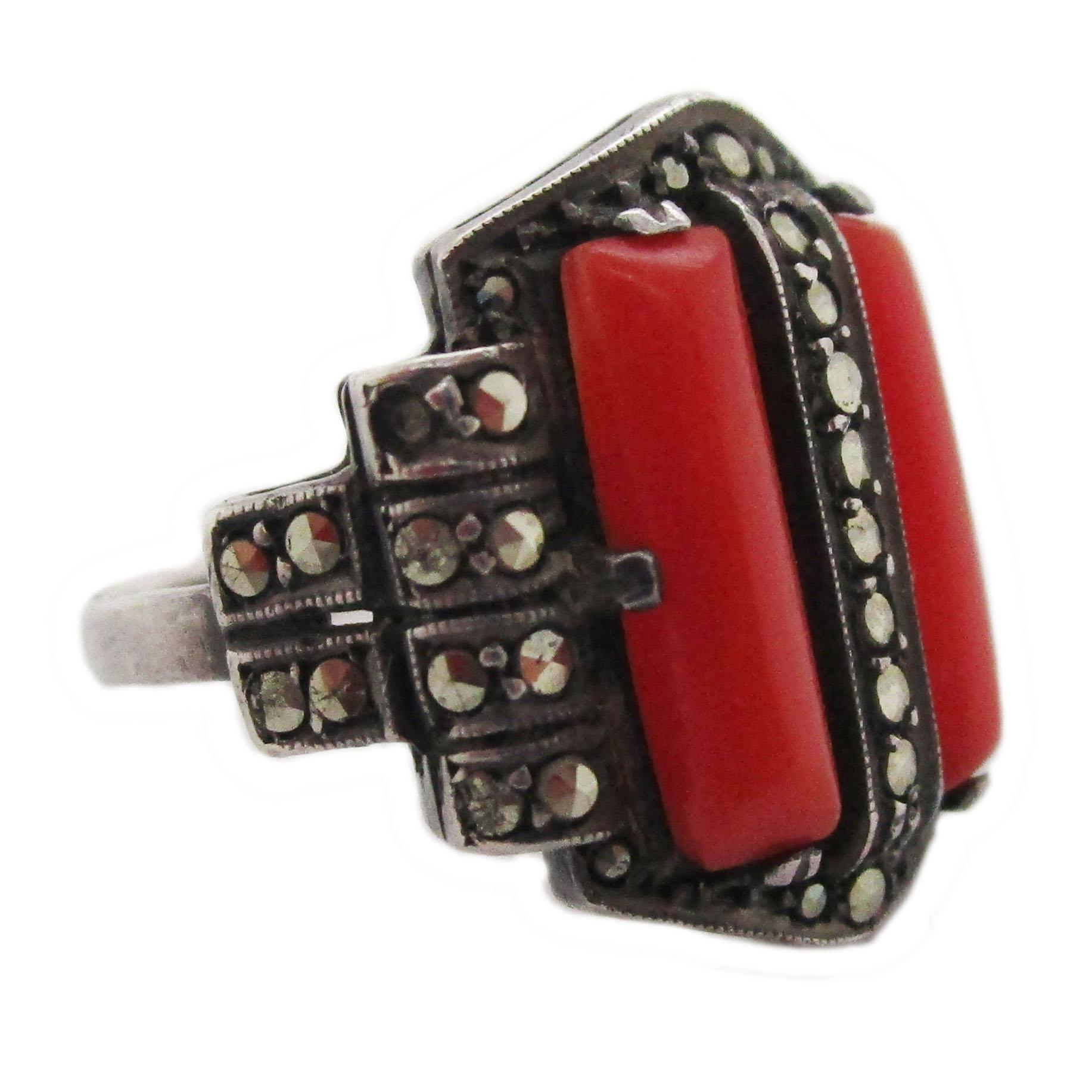 This fantastic ring is the Art Deco handiwork of Theodore Fahrner and features a flawless combination of bright sterling silver, reflective marcasite, and bright natural red coral. The hexagonal design and linear nature of the ring are classic