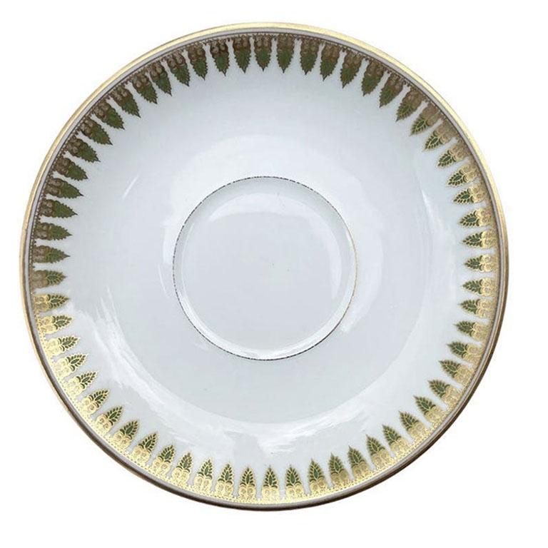 A round gilt porcelain saucer or trinket dish by Theodore Haviland. This beautiful French piece is from Limoges and features turned up edges and a flat bottom. A geometric gilt pattern surrounds the edges and is accented with a lovely mint green